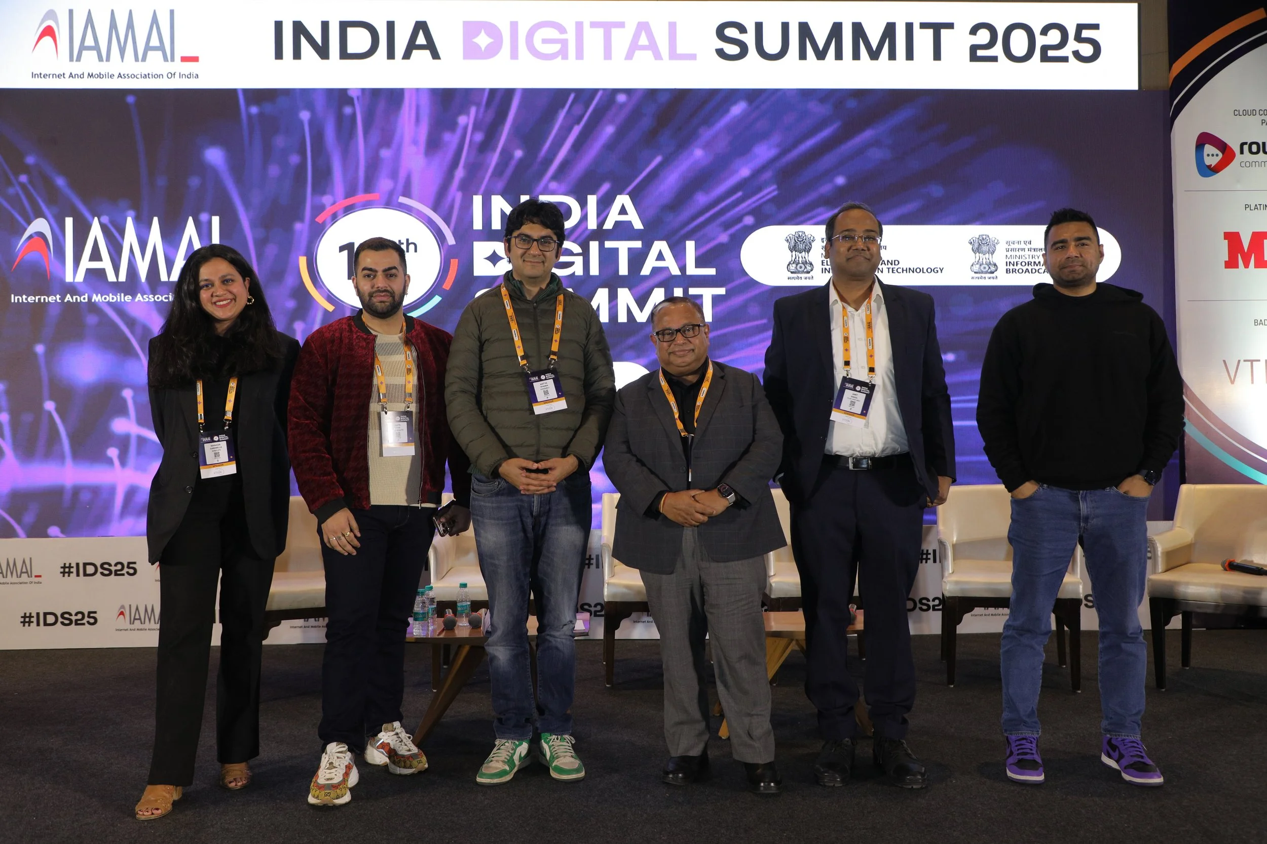 Six people standing on stage at the India Digital Summit 2025, posing for a group photo, with a large screen behind them displaying the event's logo and theme.