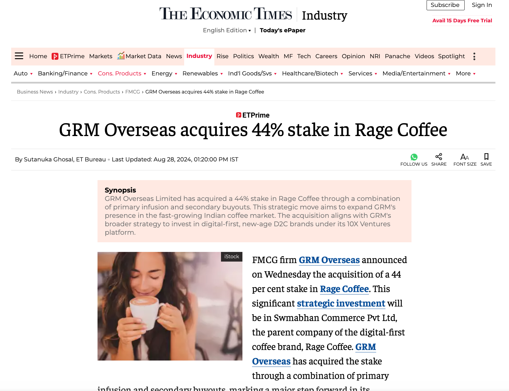 A woman holding a mug of coffee and smiling in a cozy setting.