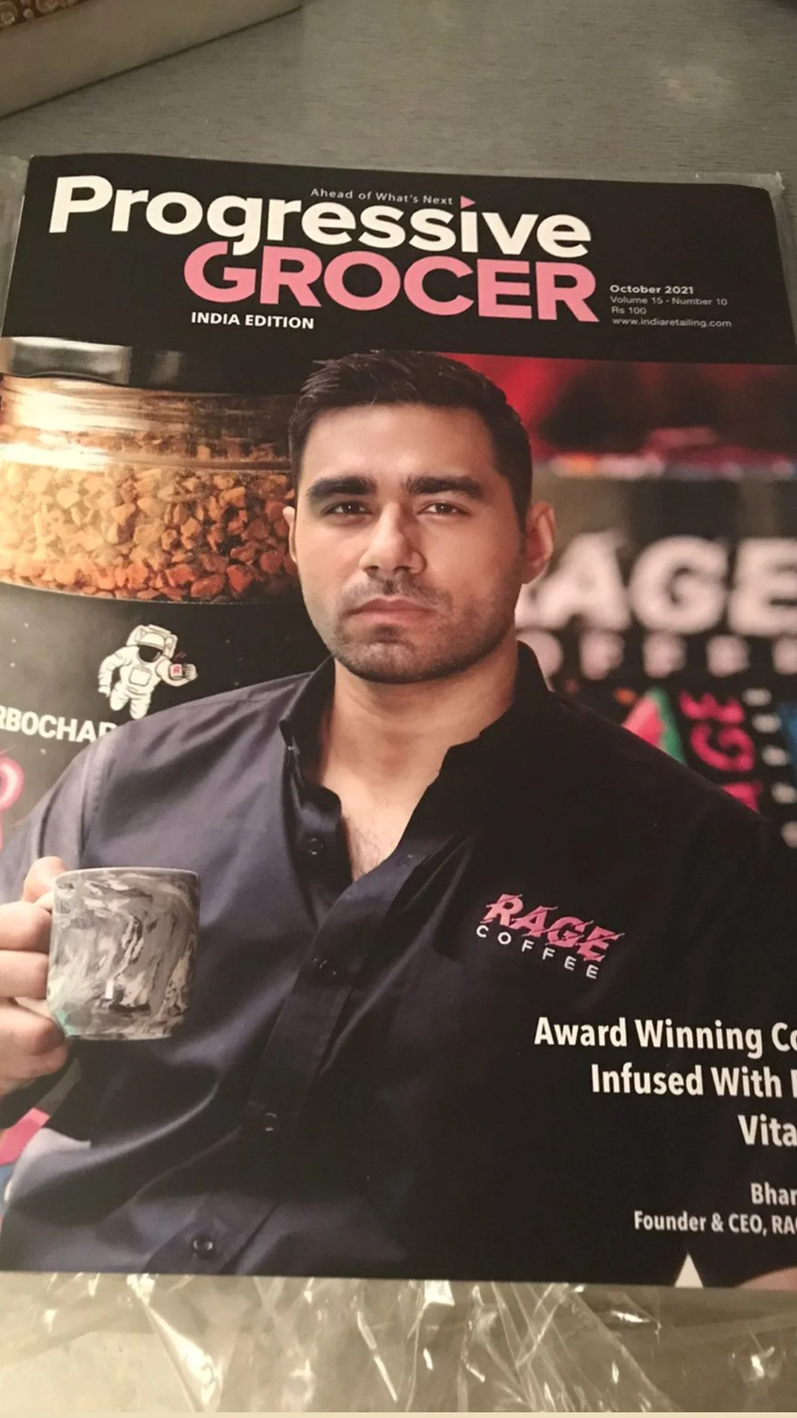 Cover of Progressive Grocer magazine featuring a man holding a coffee mug, wearing a black shirt with a 'Rage Coffee' logo, with text about award-winning coffee infused with vitamins.