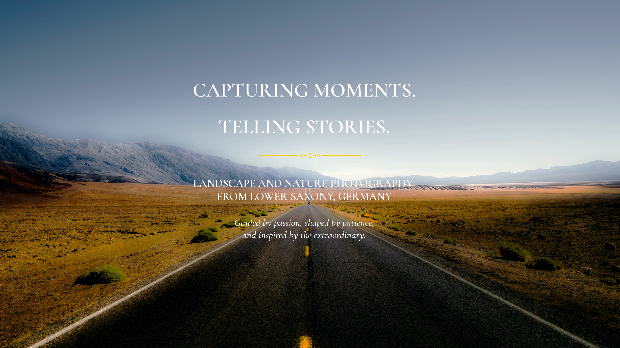 Eine Straße führt durch eine offene Landschaft mit Bergen im Hintergrund, der Himmel ist teilweise bewölkt, auf dem Bild ist ein Text mit den Worten "Capturing Moments. Telling Stories." und zusätzlichen Beschreibungen."