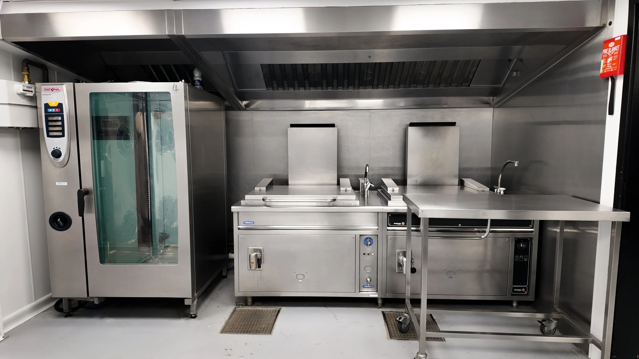 Commercial kitchen extraction canopy above fitted cooking equipment