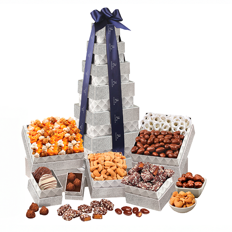 Assorted chocolates and candies in silver boxes, with a large pyramid-shaped box decorated with a navy blue ribbon.