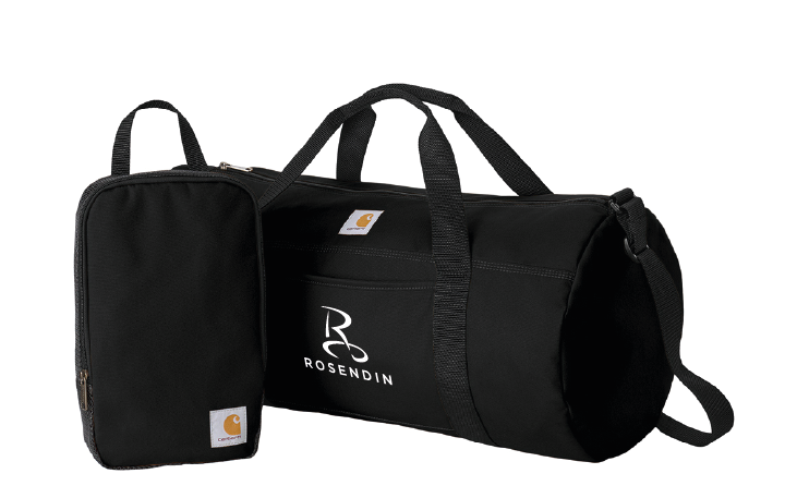 A black duffel bag with handles and a shoulder strap, alongside a smaller matching black pouch, both featuring the Carhartt logo and the initials 'RB ROSENDIN' printed on the duffel bag.