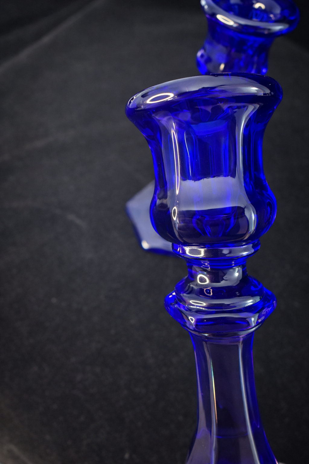 Cobalt blue candlesticks on black surface.png