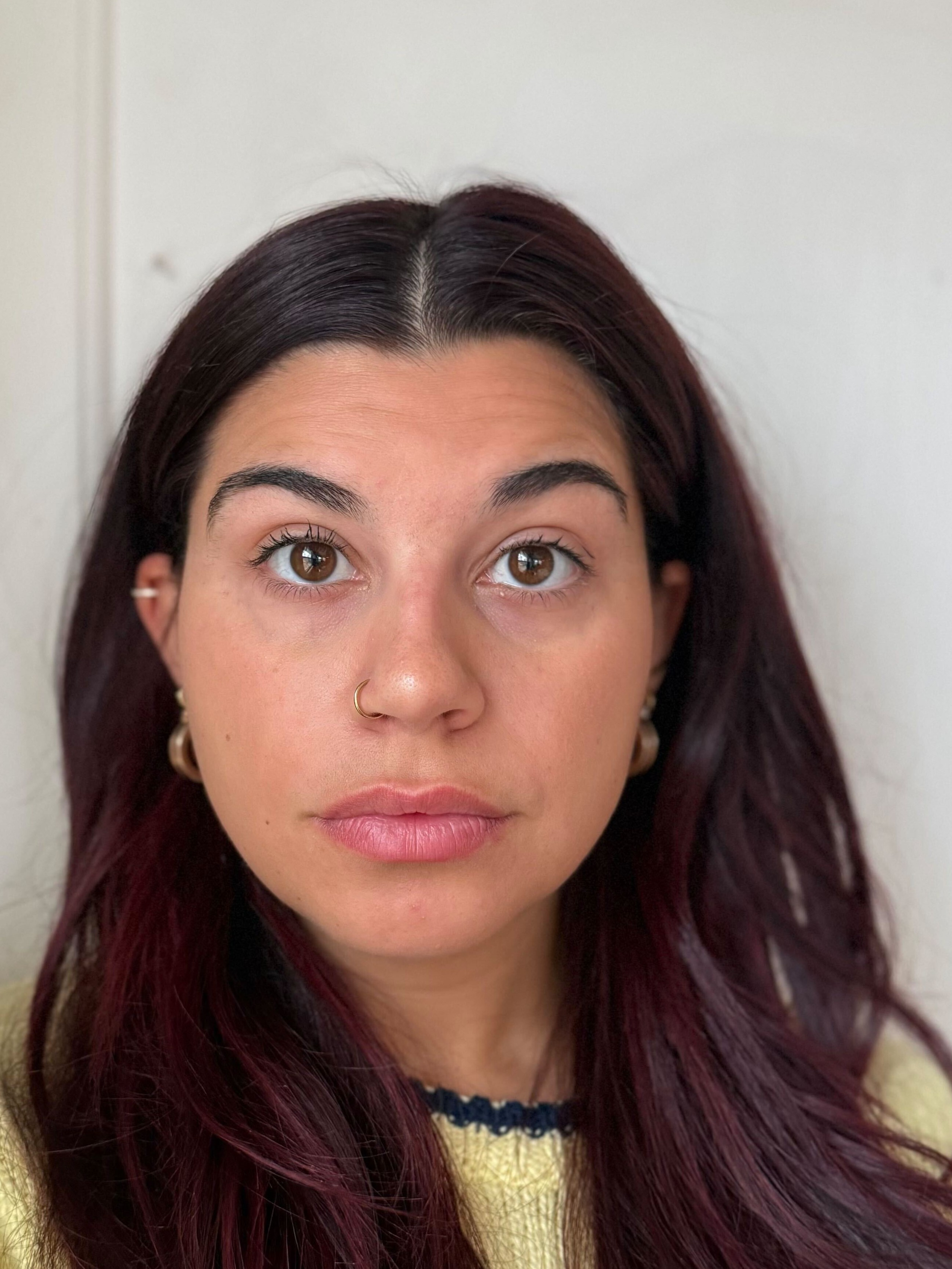 A woman with medium skin tone, brown eyes, and dark red hair looking slightly upward.