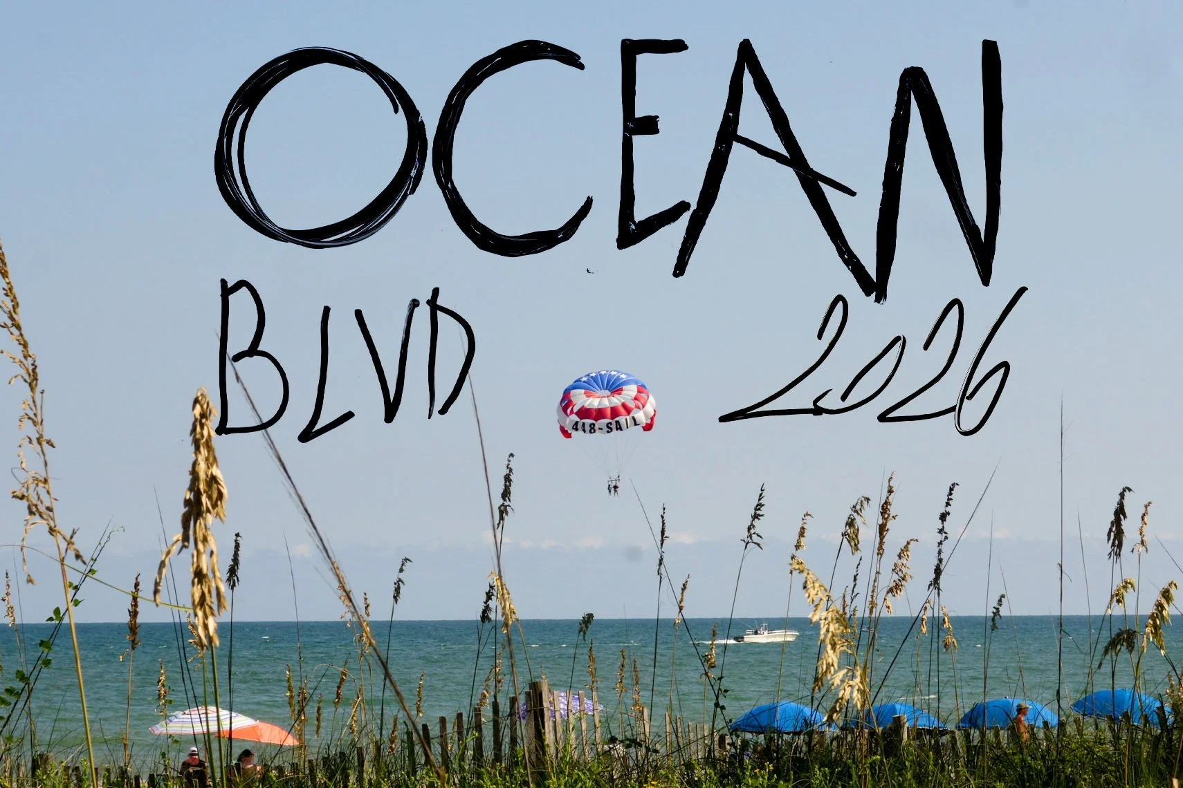 A beach scene with tall grass in the foreground, a large sky in the background, and the ocean. A parachute with the number 448-SALT is descending from the sky. Handwritten words "OCEAN BND 2026" are superimposed on the image.