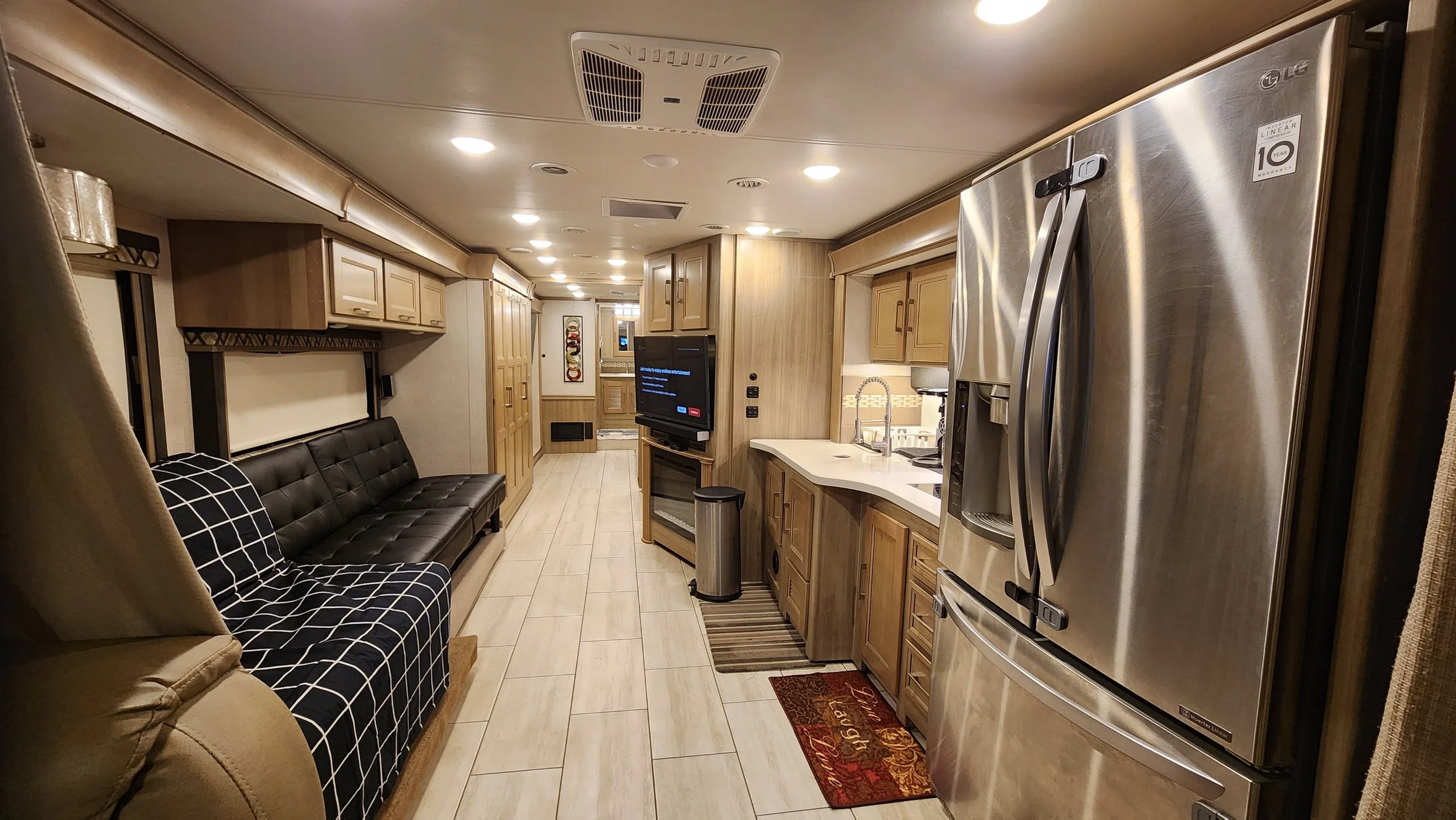 Interior of a recreational vehicle or camper with kitchen, seating area, and hallway.