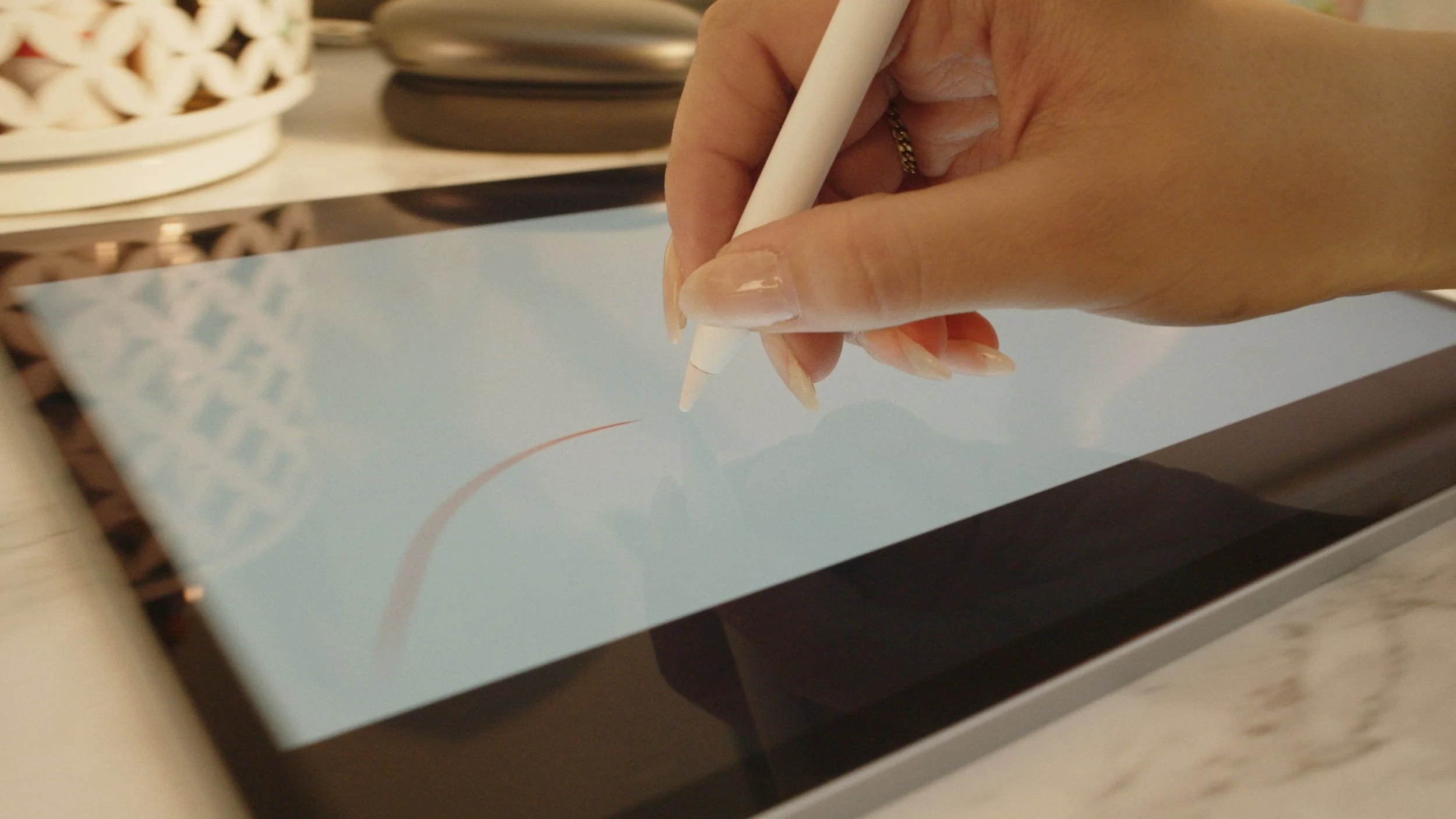 Person using a stylus to draw on a digital tablet screen