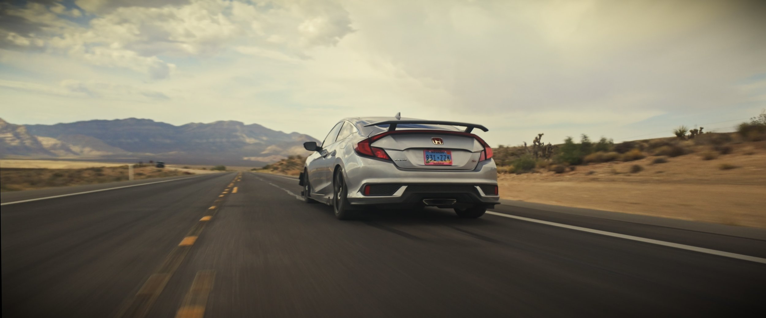 Honda Civic driving away - rear view with taillights visible