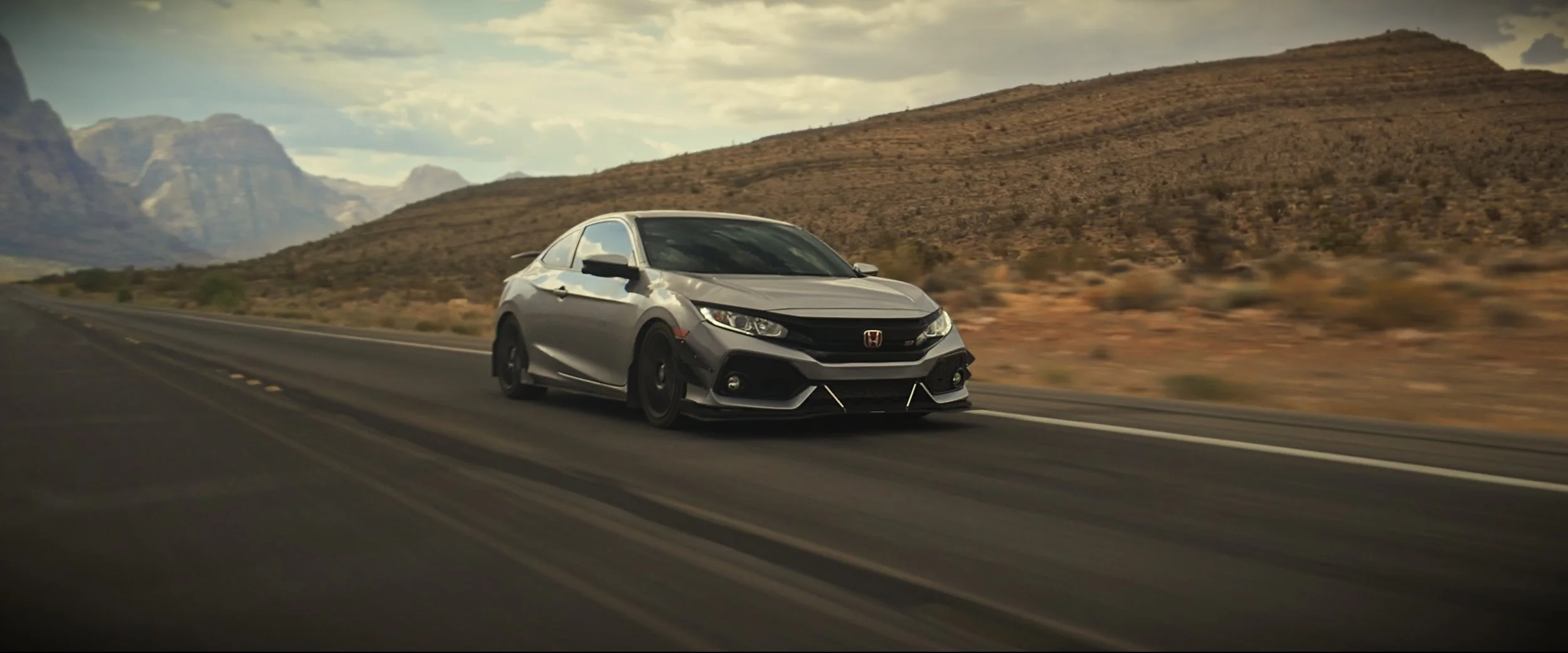 Honda Civic driving forward on road - front view