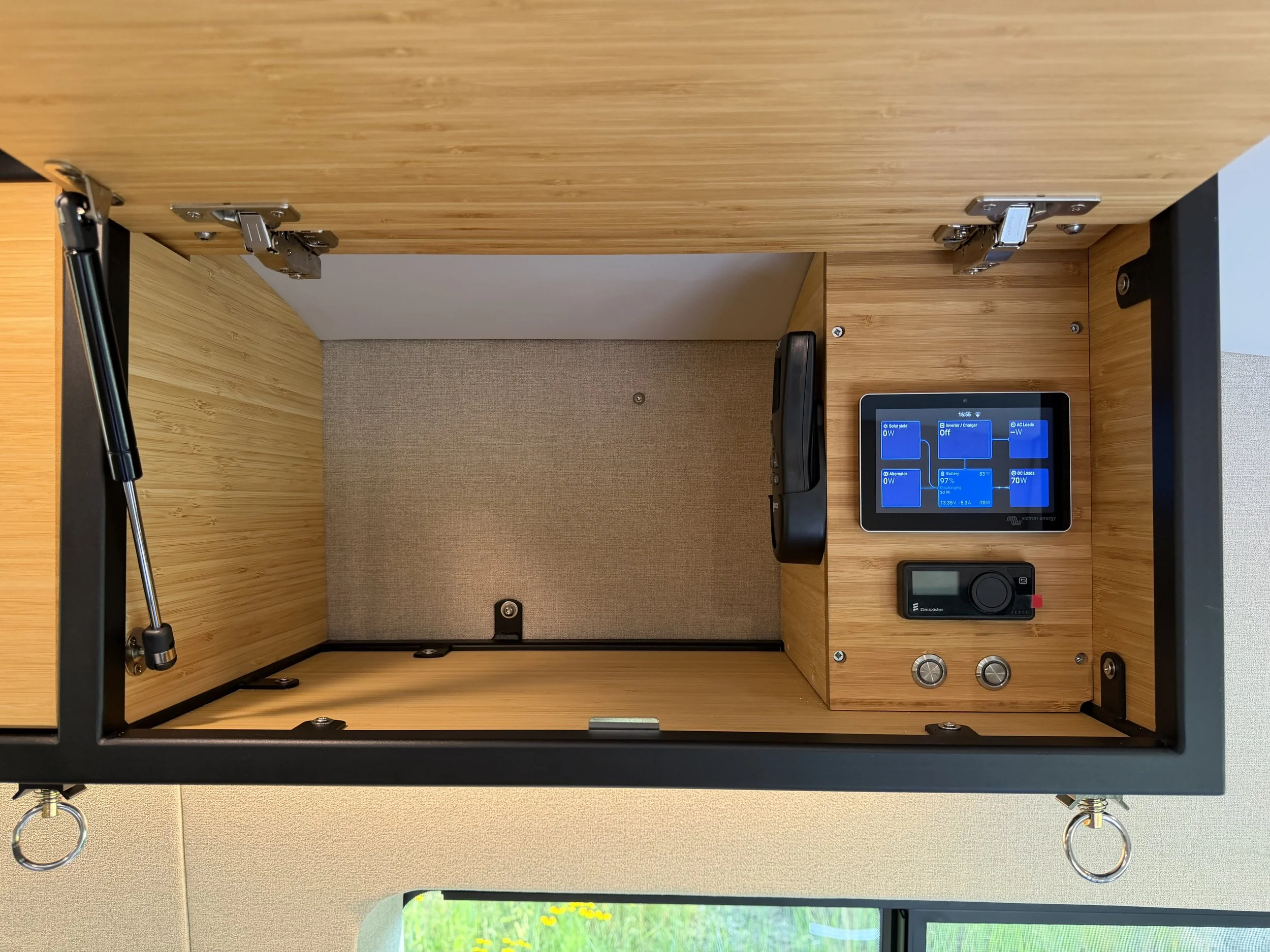 Interior view of an empty workspace with a wooden tabletop, a touchscreen control panel on the right, and metal hinges underneath the tabletop.