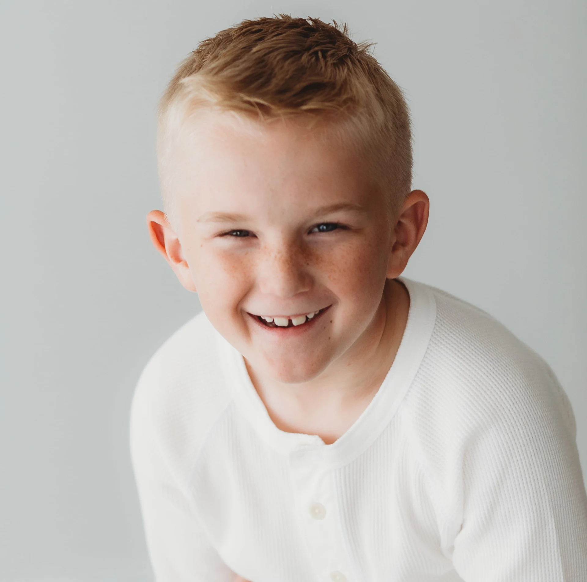 Smiling young boy in a white shirt