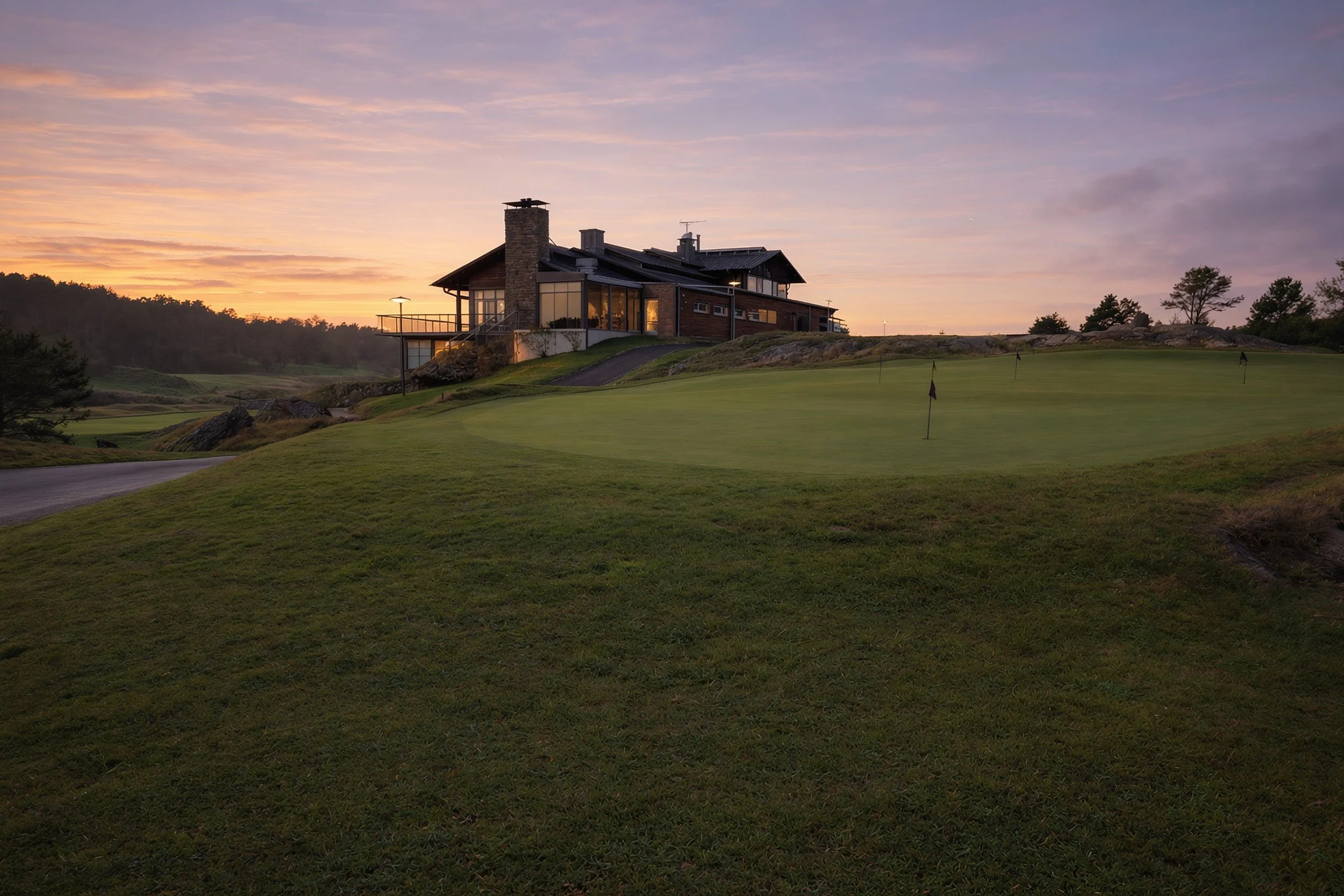 Clubhouse overlooking the putting green at Shoal Creek Golf Course, Missouri at dusk.
