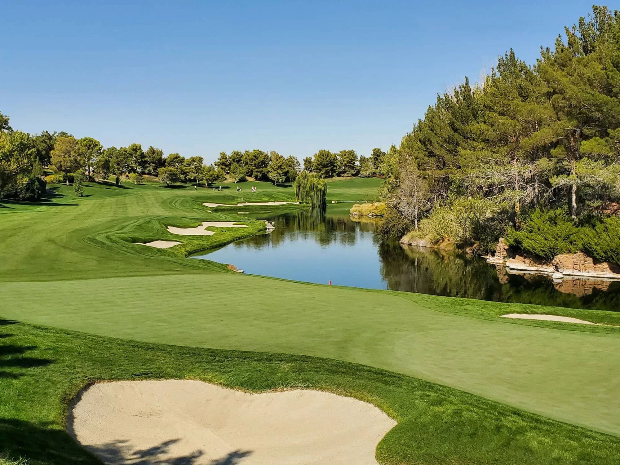 Scenic fairway with sand bunkers and pond at a private golf course in the Kansas City area.