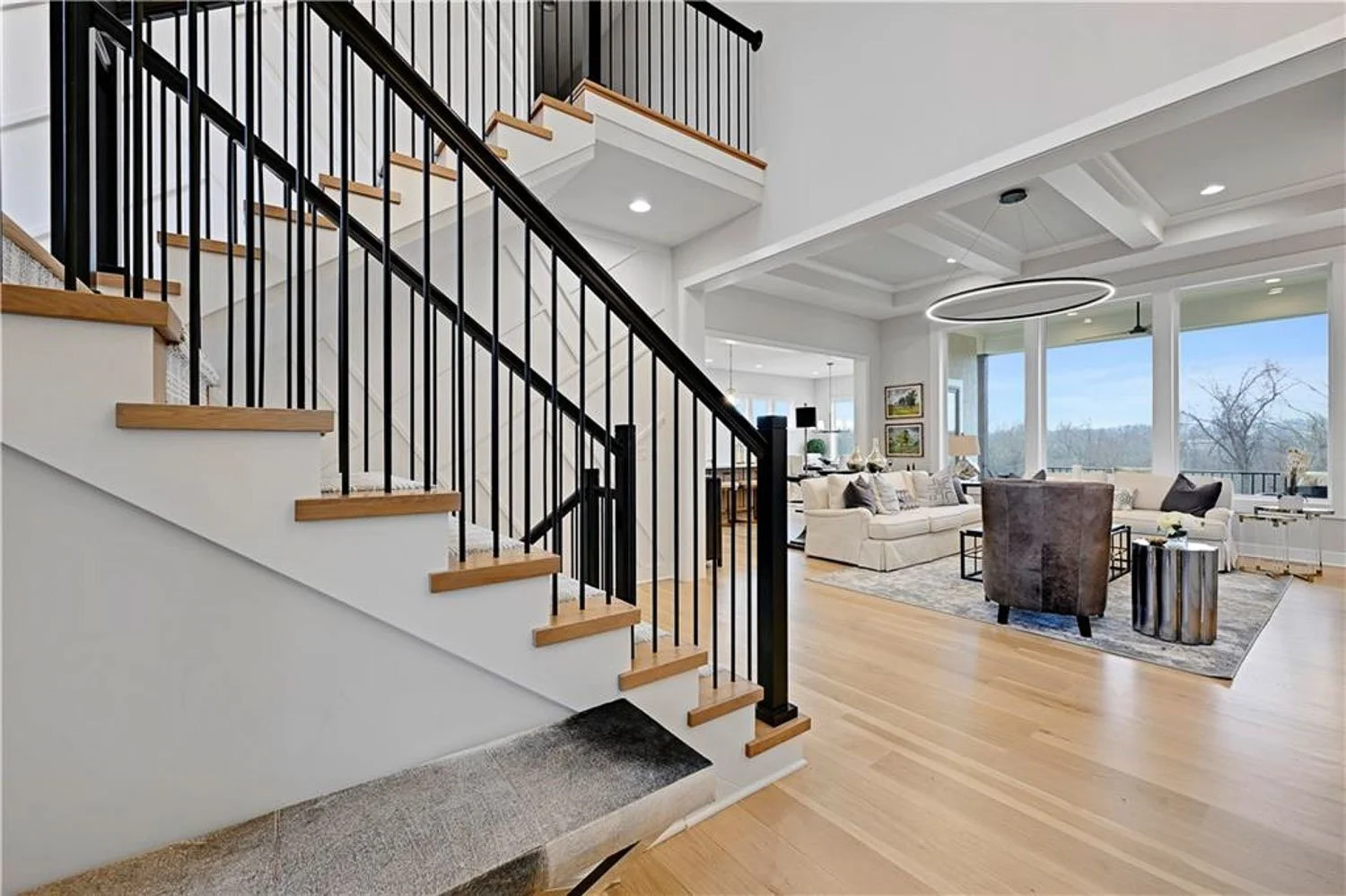 Staircase and open floor plan inside an Overland Park home for sale in a new construction community.