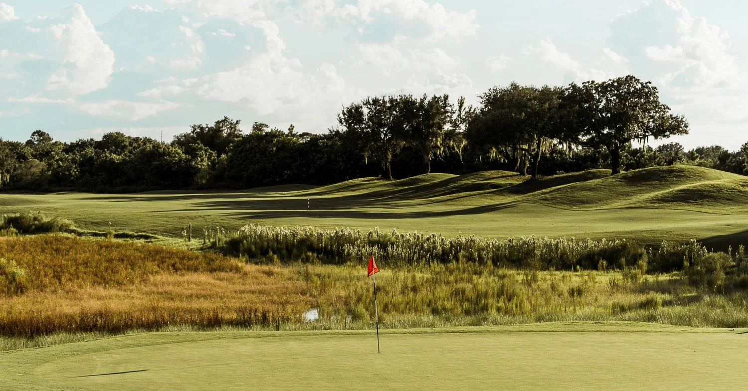 Wide view of a well-manicured fairway at one of the best Kansas City golf courses, surrounded by mature trees.