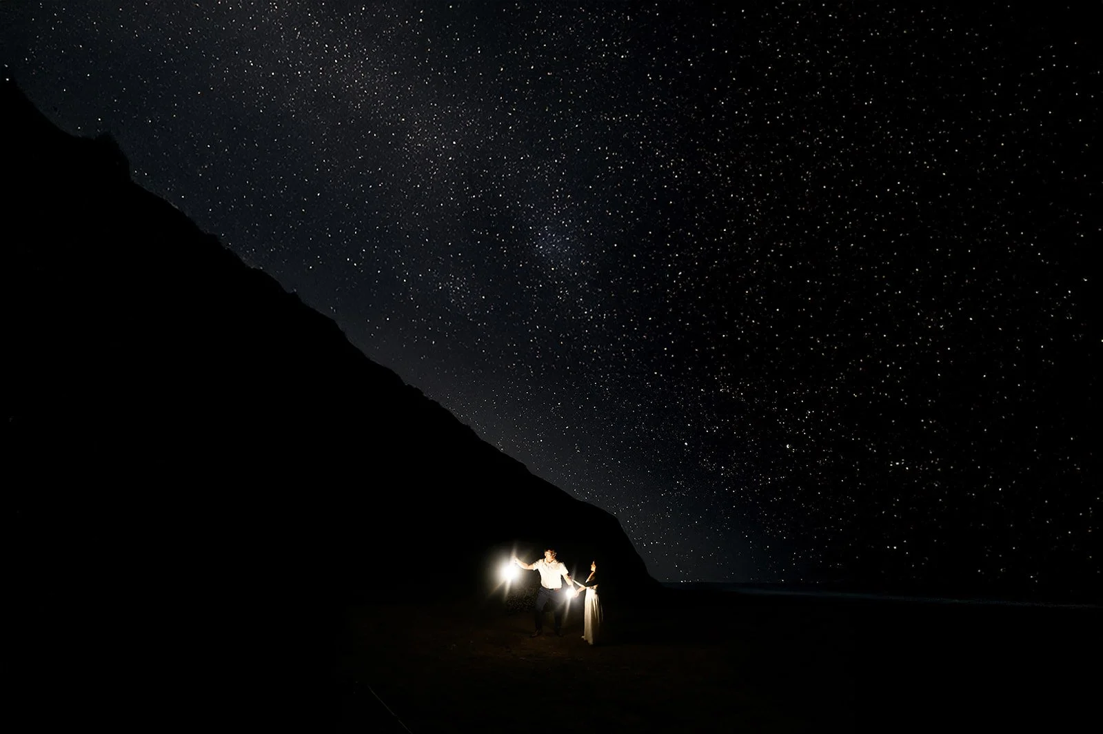 bride and groom at night in big sur with stars above them