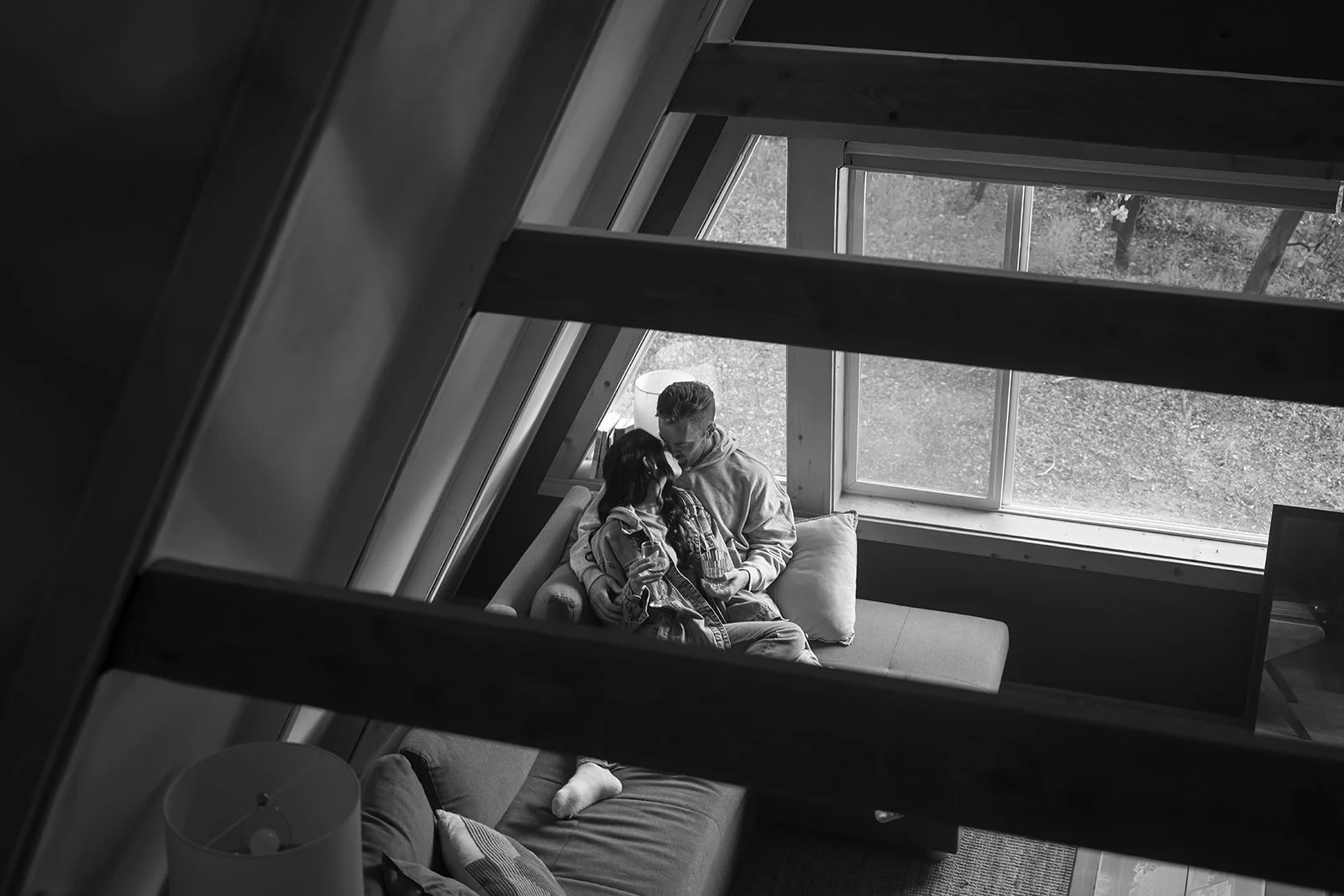 a couple cuddling on a coach in an A-framed cabin in Yosemite