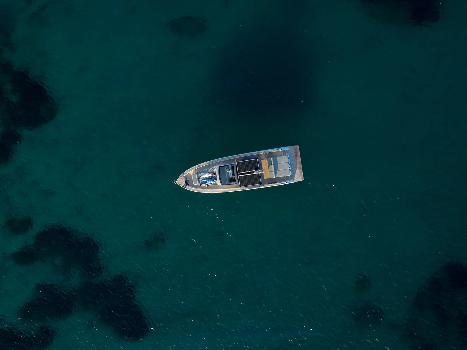 a bride and a groom laying together on a boat with clear blue water around them