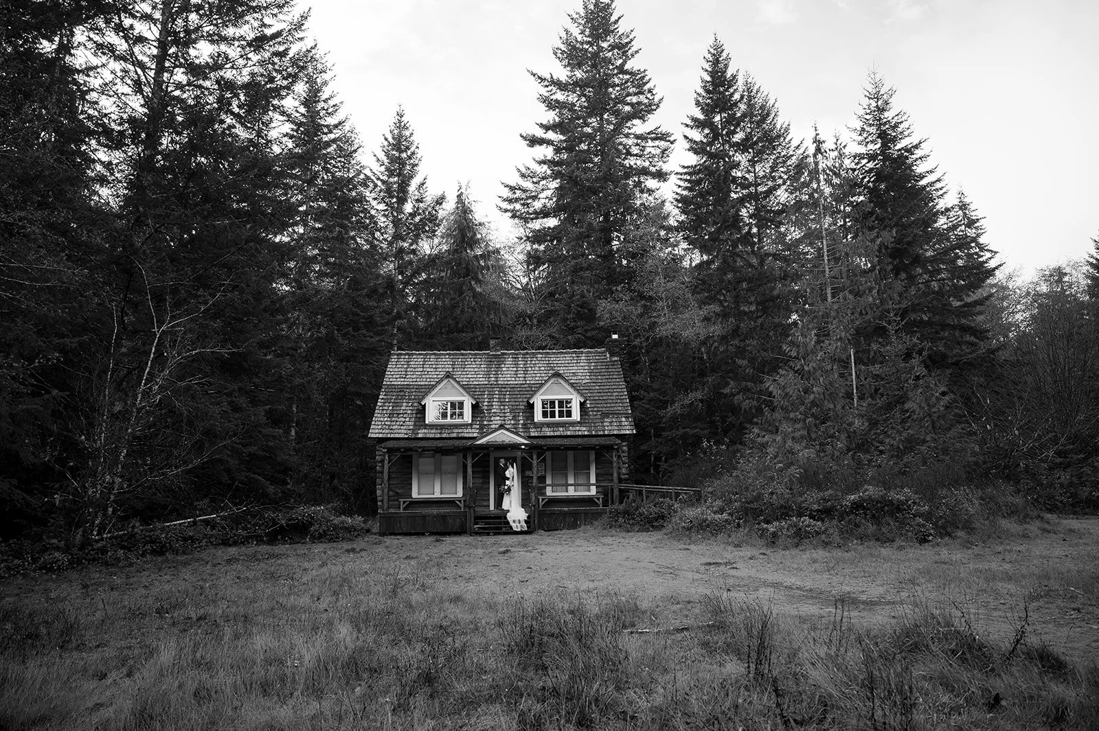 A bride and groom in front of a cabin in the woods for their elopement in Olympic National Park