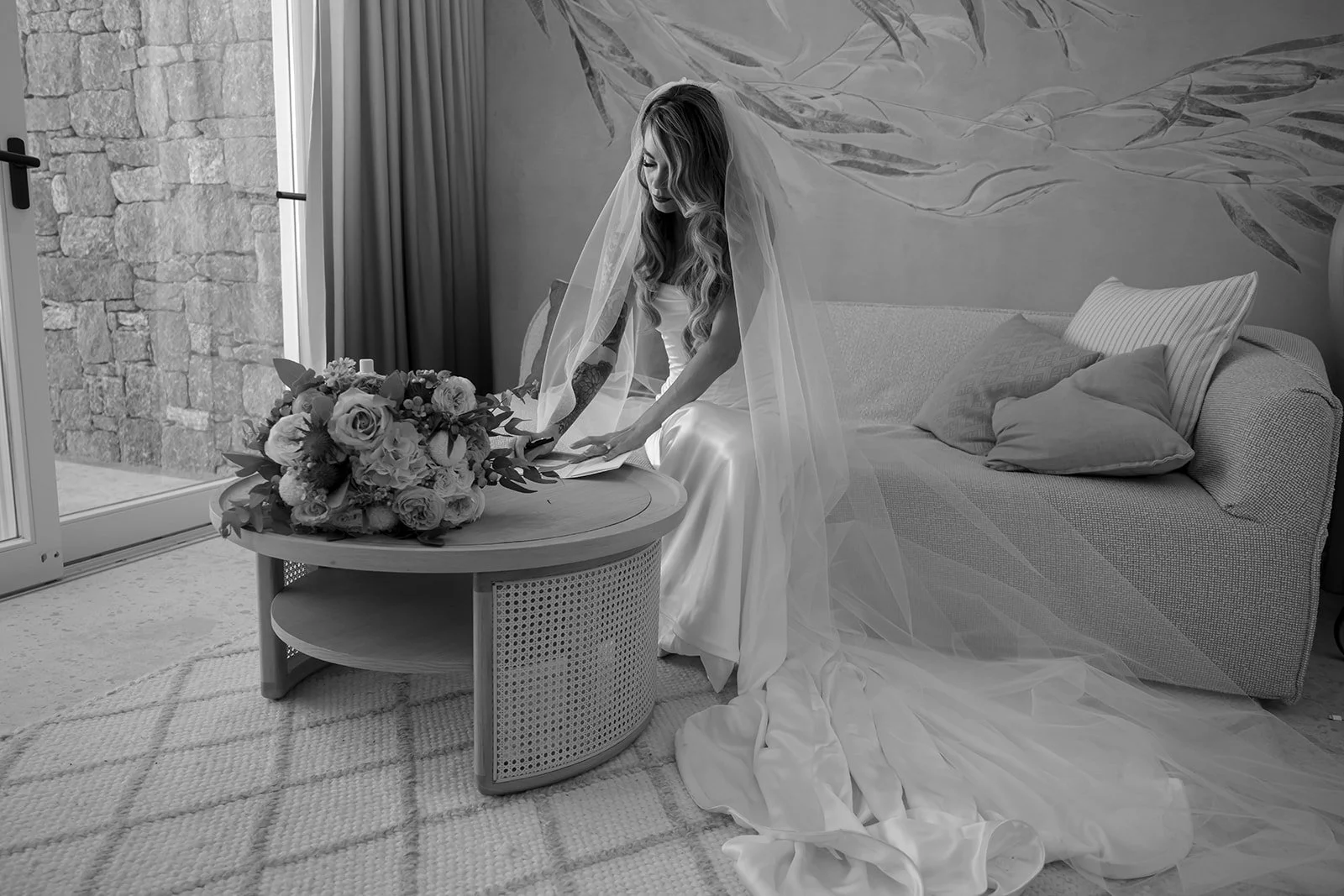 A bride writing her vows in her hotel before their wedding starts in black and white