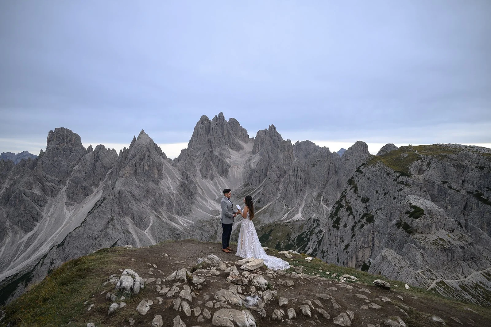 a bride and groom reading their vows to each other at cadini di misurina in the dolomites