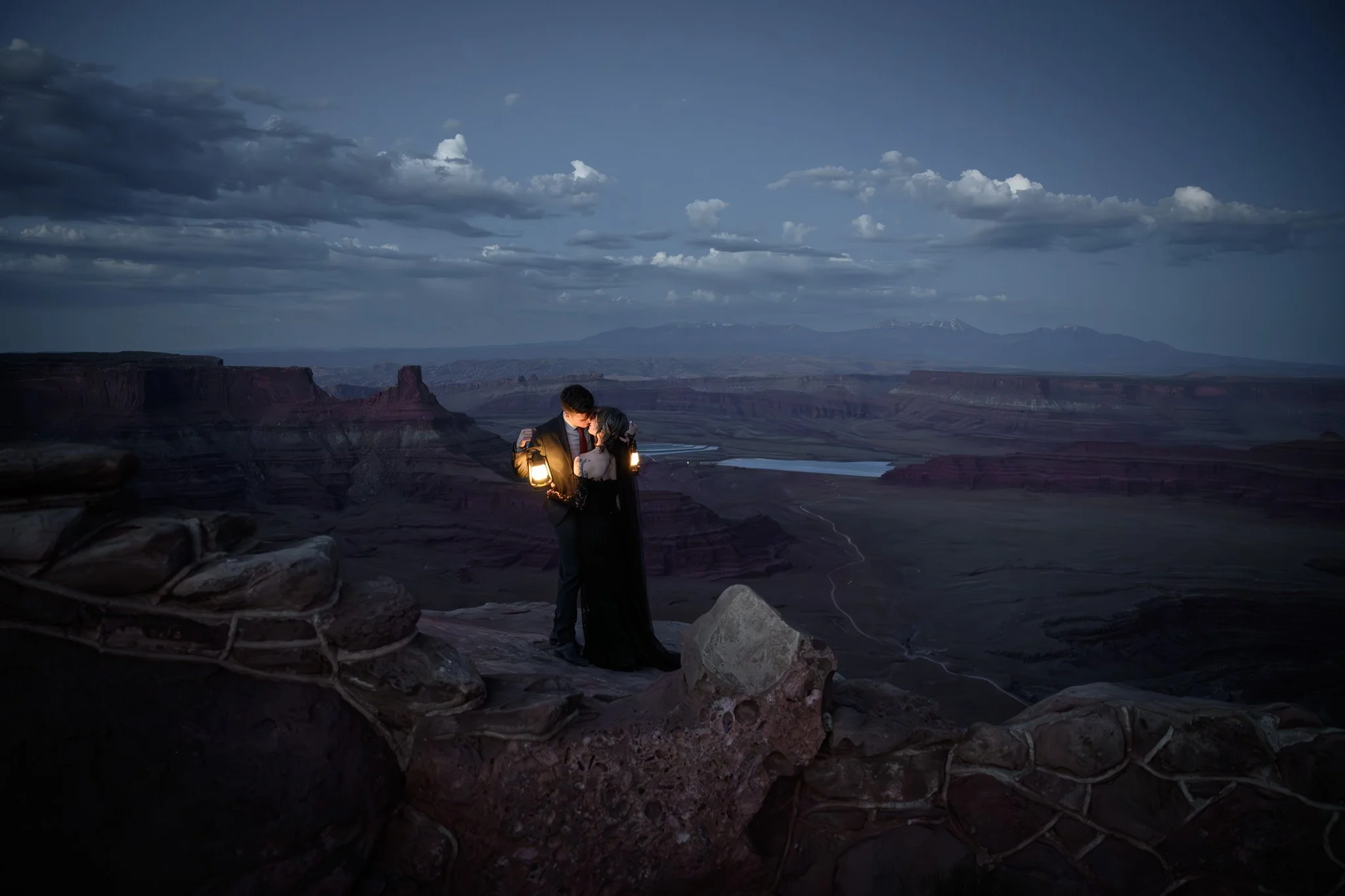 bride and groom at night in Moab with lanterns and with stars above them