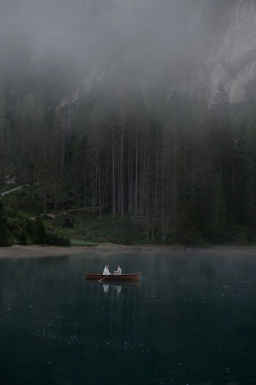 bride and groom on a rowboat in the Dolomites for their wedding