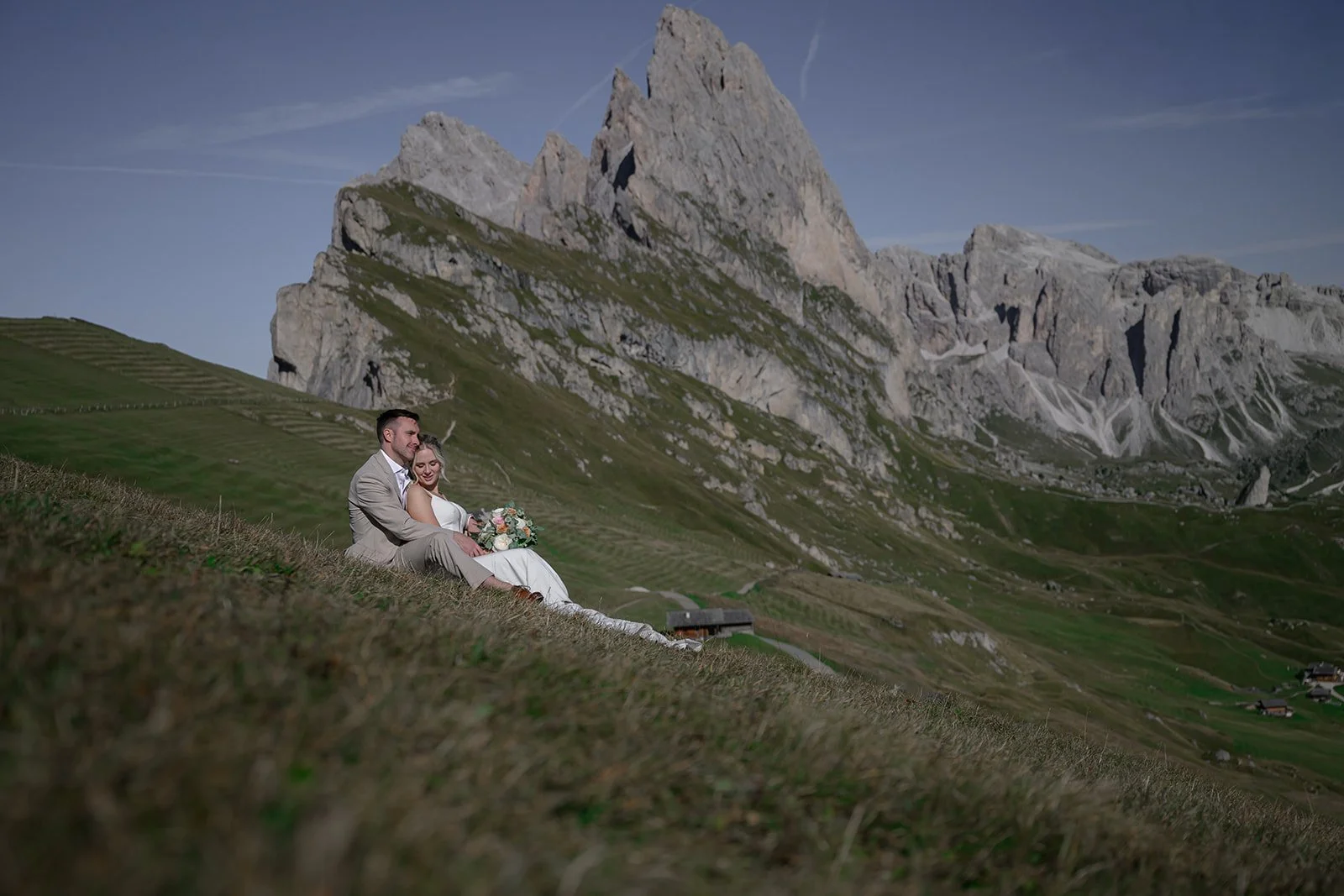 a bride sitting on a grooms lap at Seceda in the dolomites