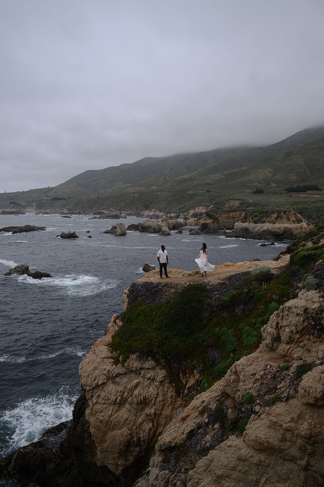 bride and groom on a cliff in big sur