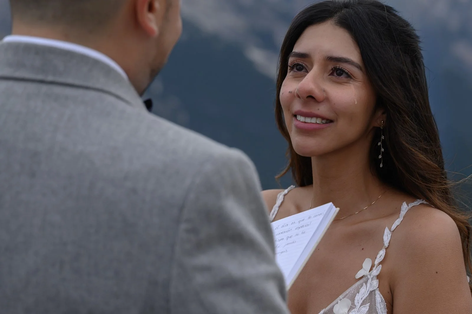 a photo of a groom reading a bride his vows in the italian dolomites and a tear is sliding down the brides cheek