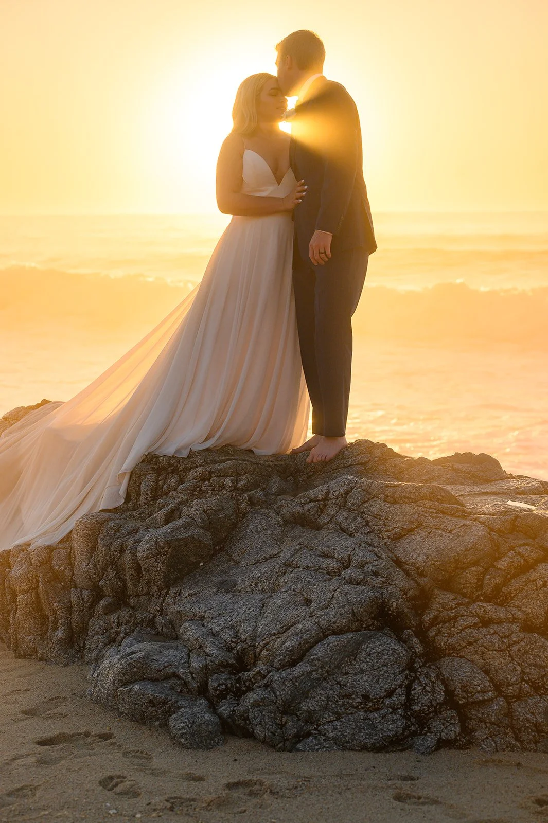 bride and groom on a beach in big sur at sunset 