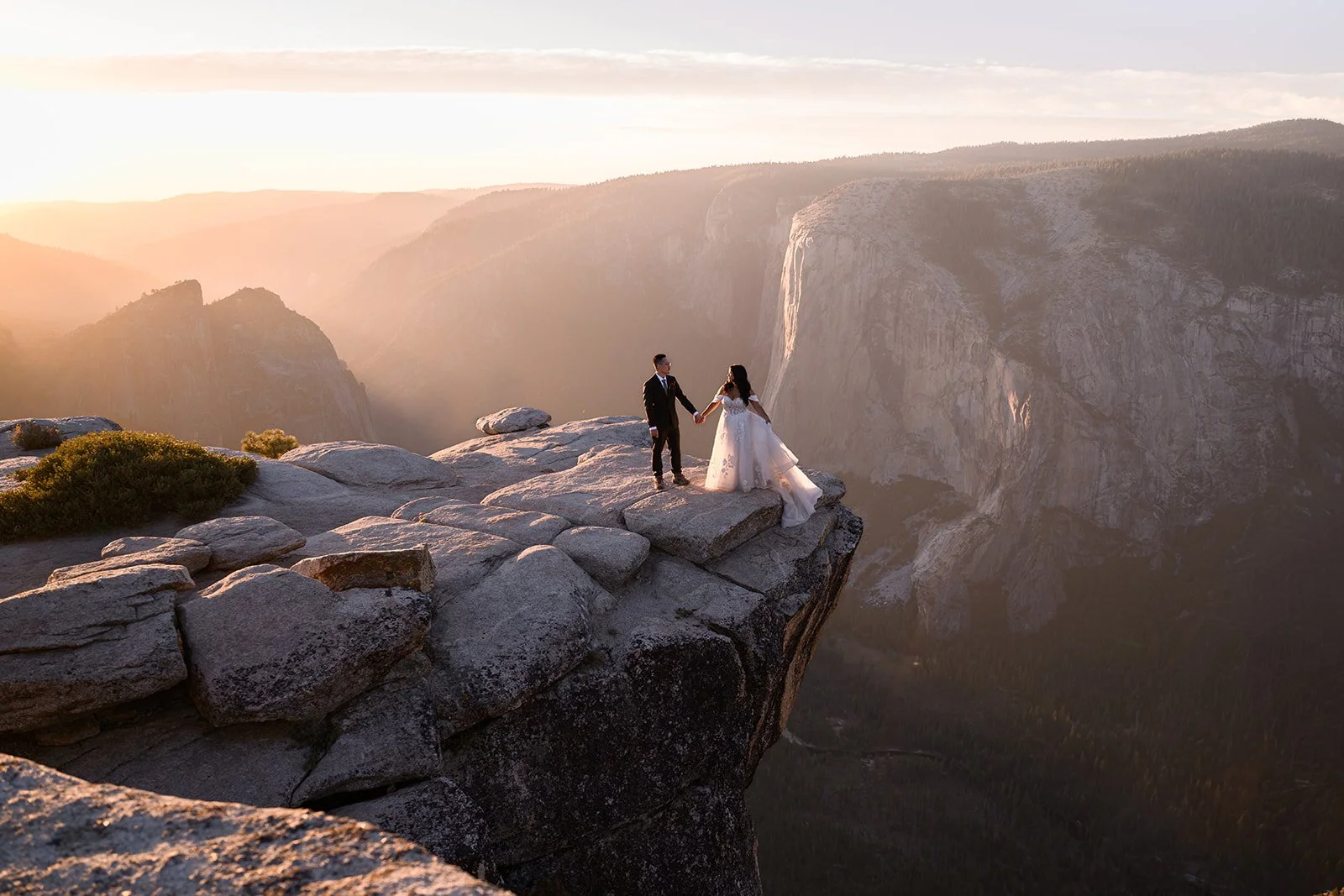 a photo of a bride and groom at taft point in Yosemite at sunset