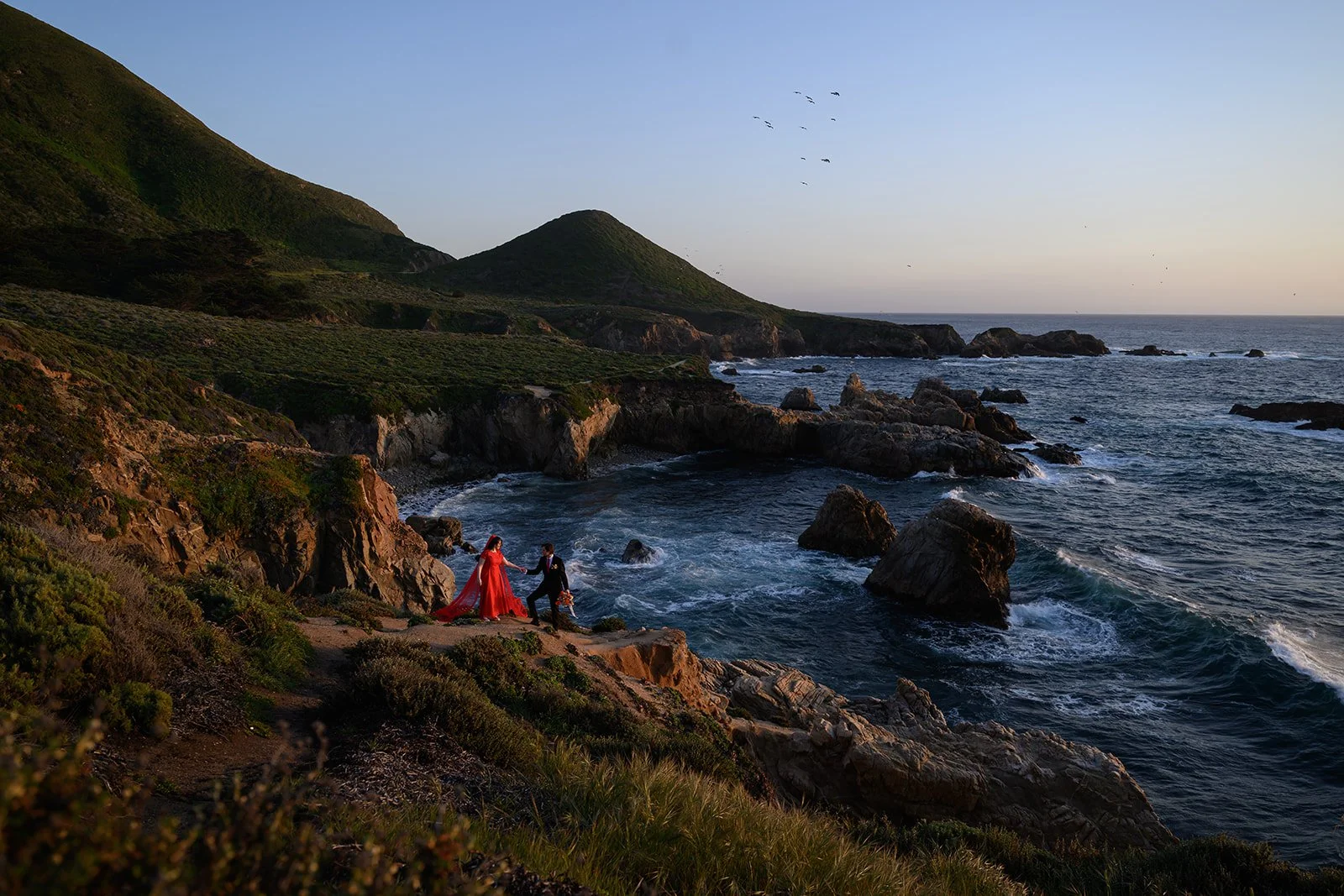 Red wedding dress couple on a cliffside at sunset in Big Sur on their wedding day
