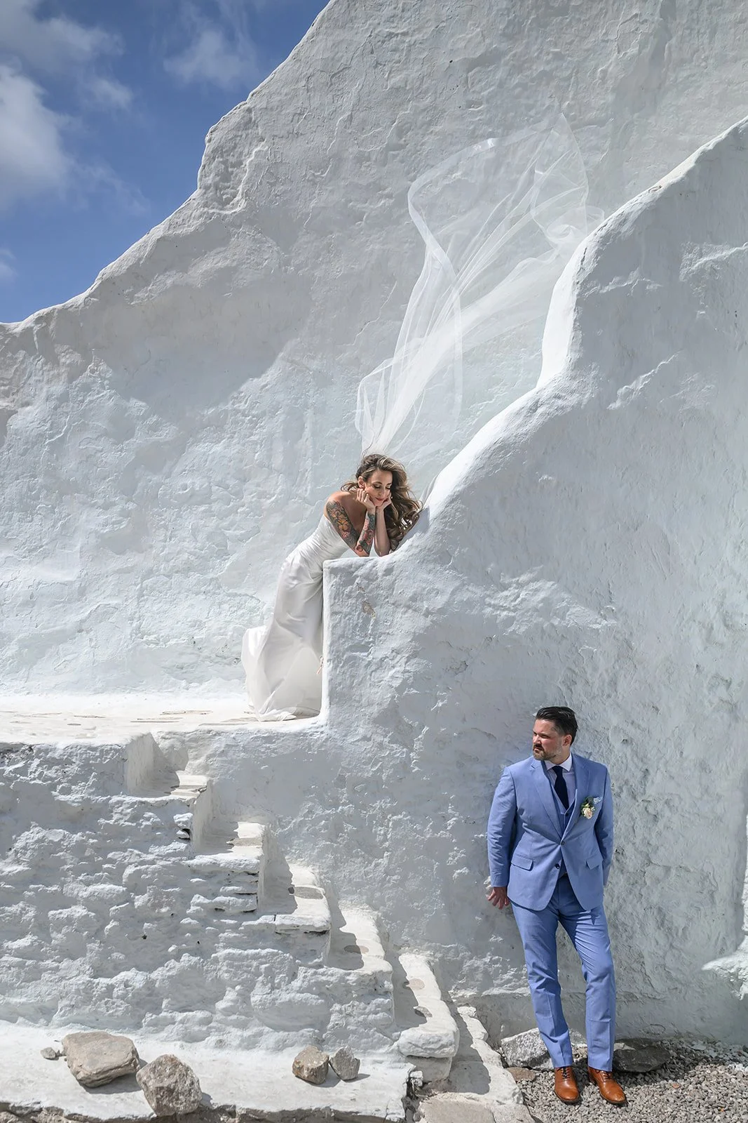 A couple at their wedding in Mykonos, Greece in their wedding outfits