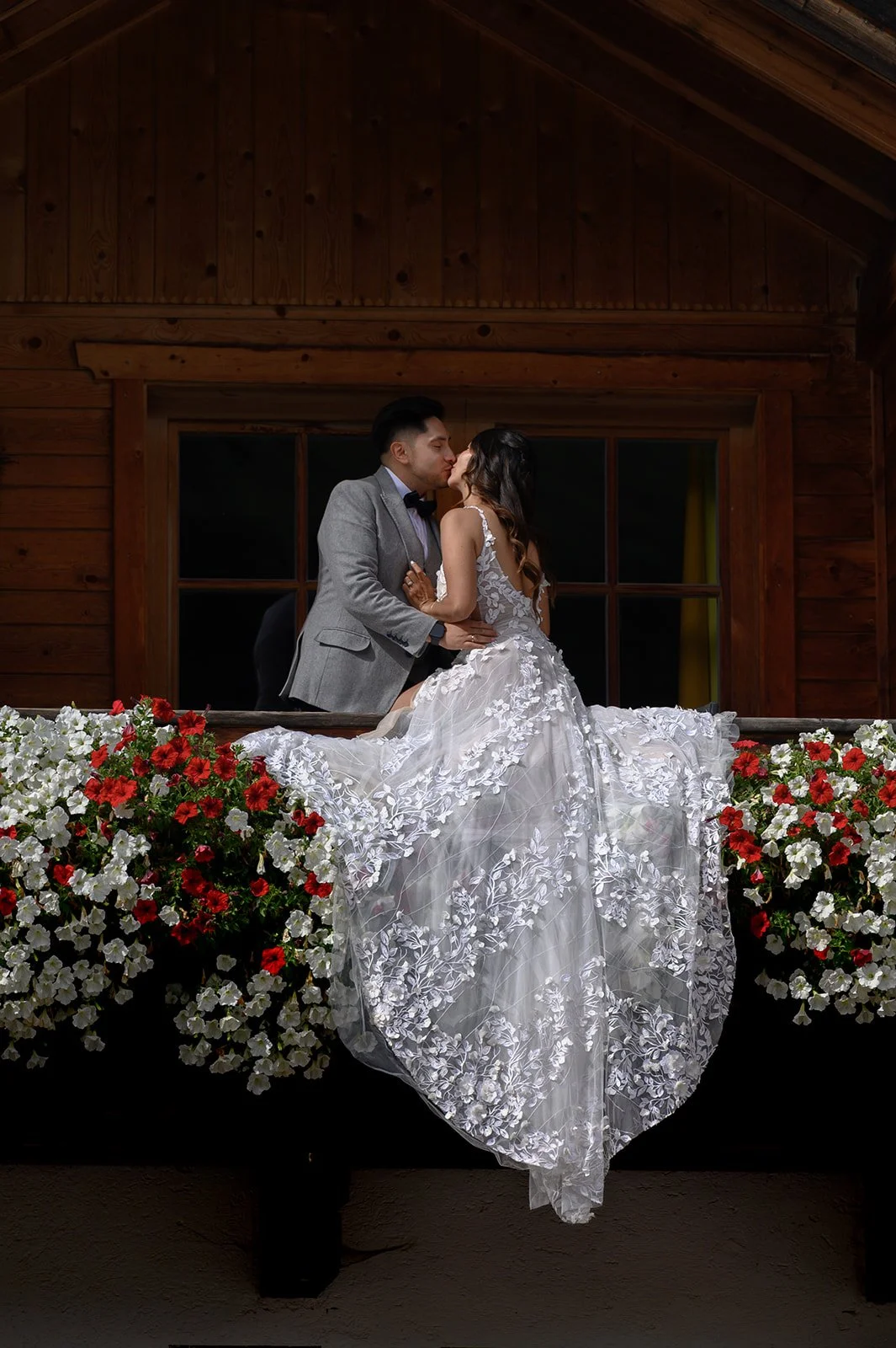 a couple sitting on their balcony in the flowers in the Dolomites in Italy on their wedding day
