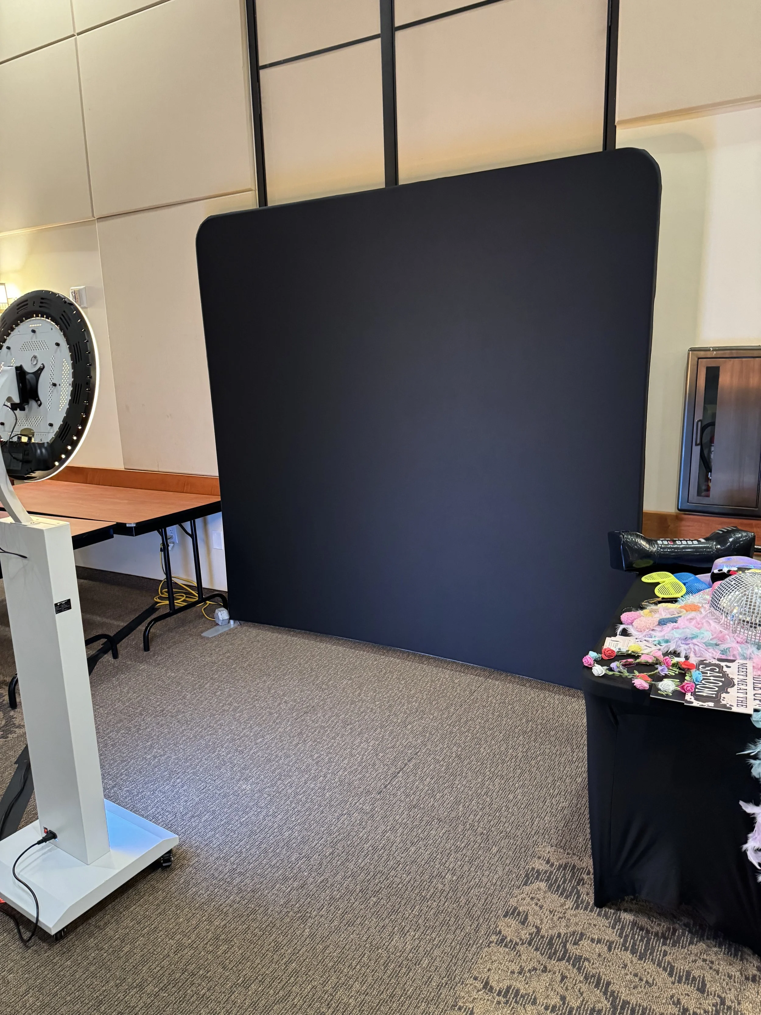 A smiling woman wearing sunglasses holds a drink, standing next to a smiling man holding a 