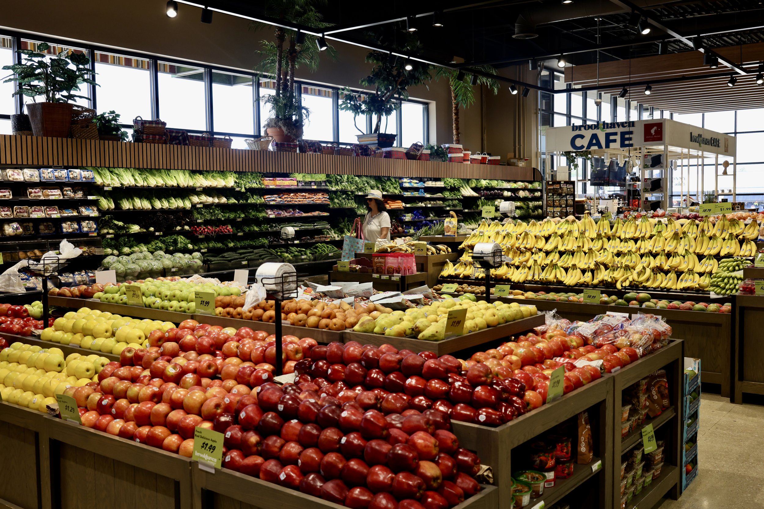 Interior of a grocery store produce section with an array of colorful apples, bananas, and vegetables on display.