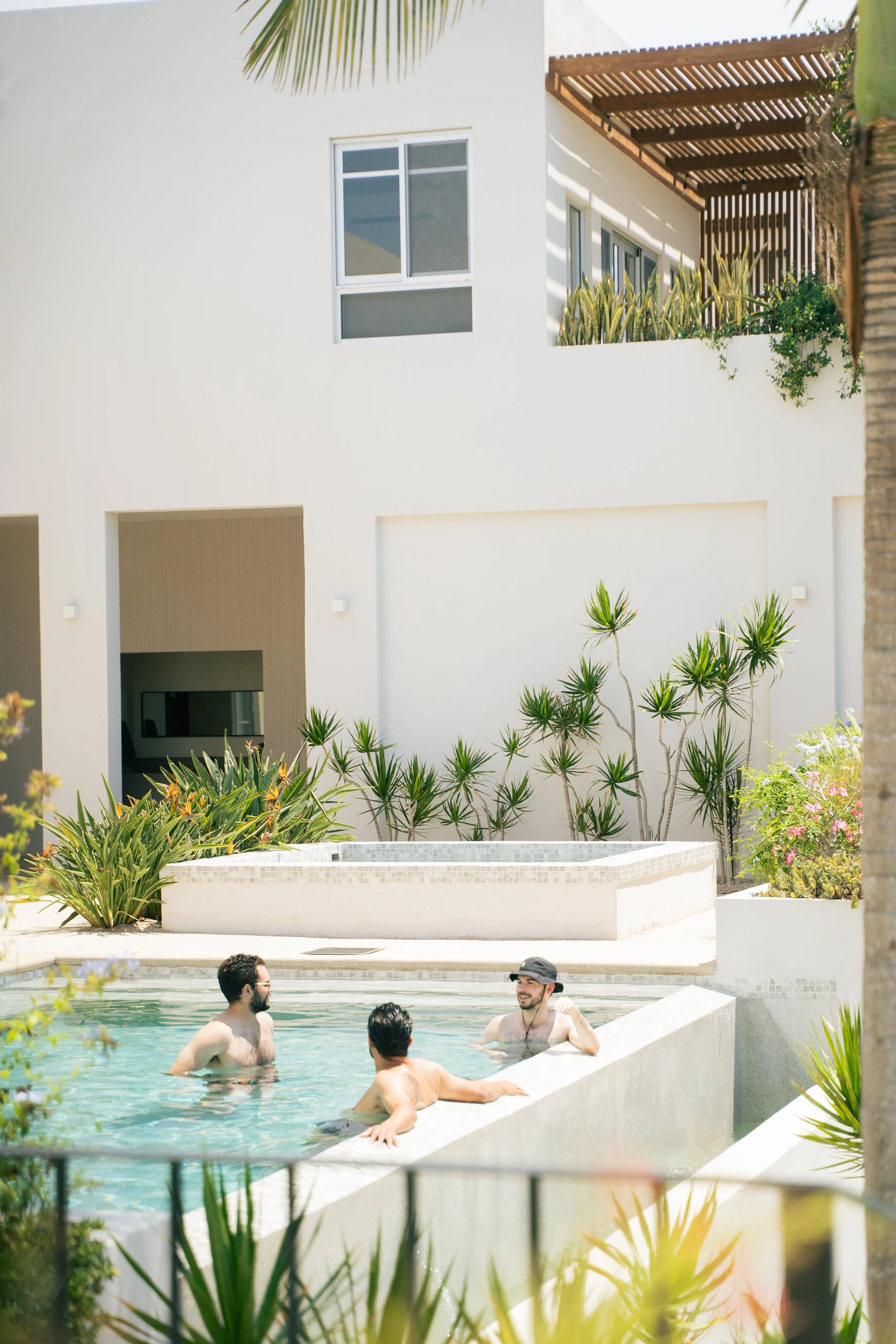 Three men connect with each other at a somatic retreat for men in Baja California in between men's work sessions.