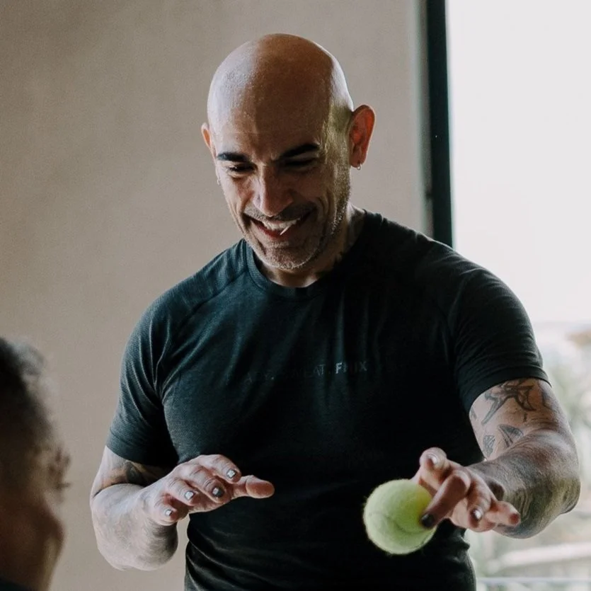 A man in his 40's has fun playing somatic reflex games with his partner at SHIFT Men's Retreat. He is having fun and he is clearly relaxed.