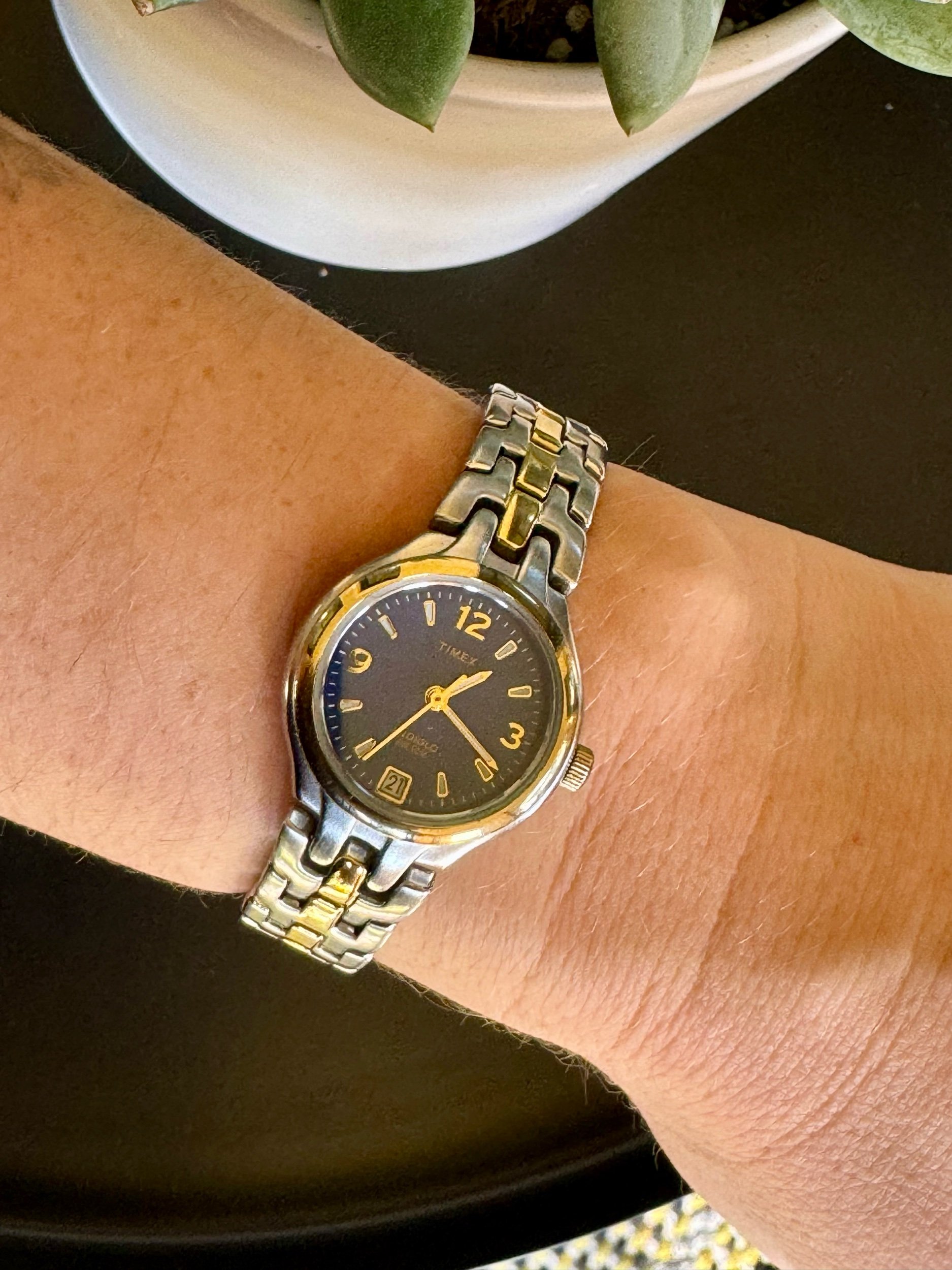 Side profile of the silver and gold-tone Timex watch with a striking blue face, showcasing timeless two-tone elegance