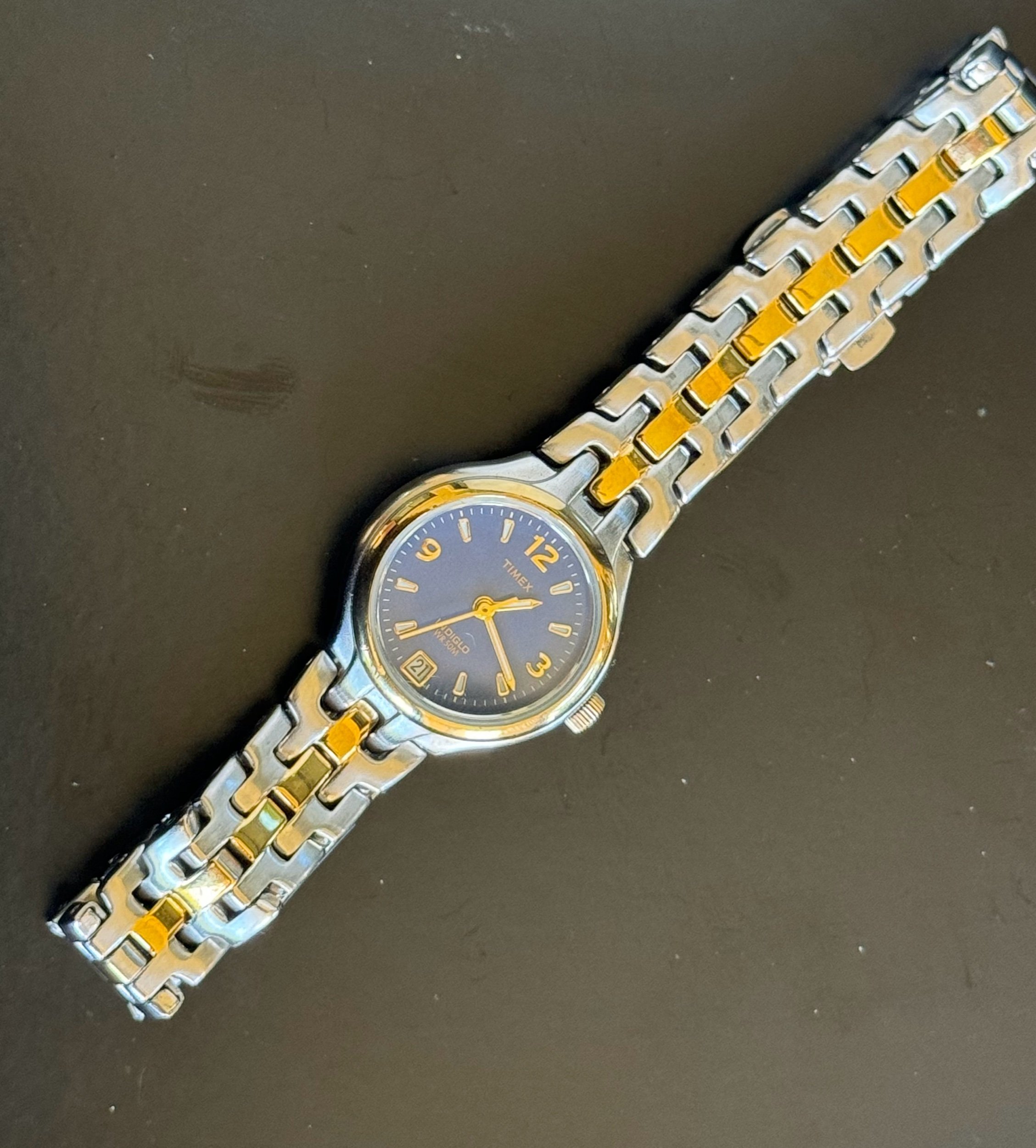 Vintage Timex watch with a silver and gold-tone metal band and vibrant blue face. Requires a new battery
