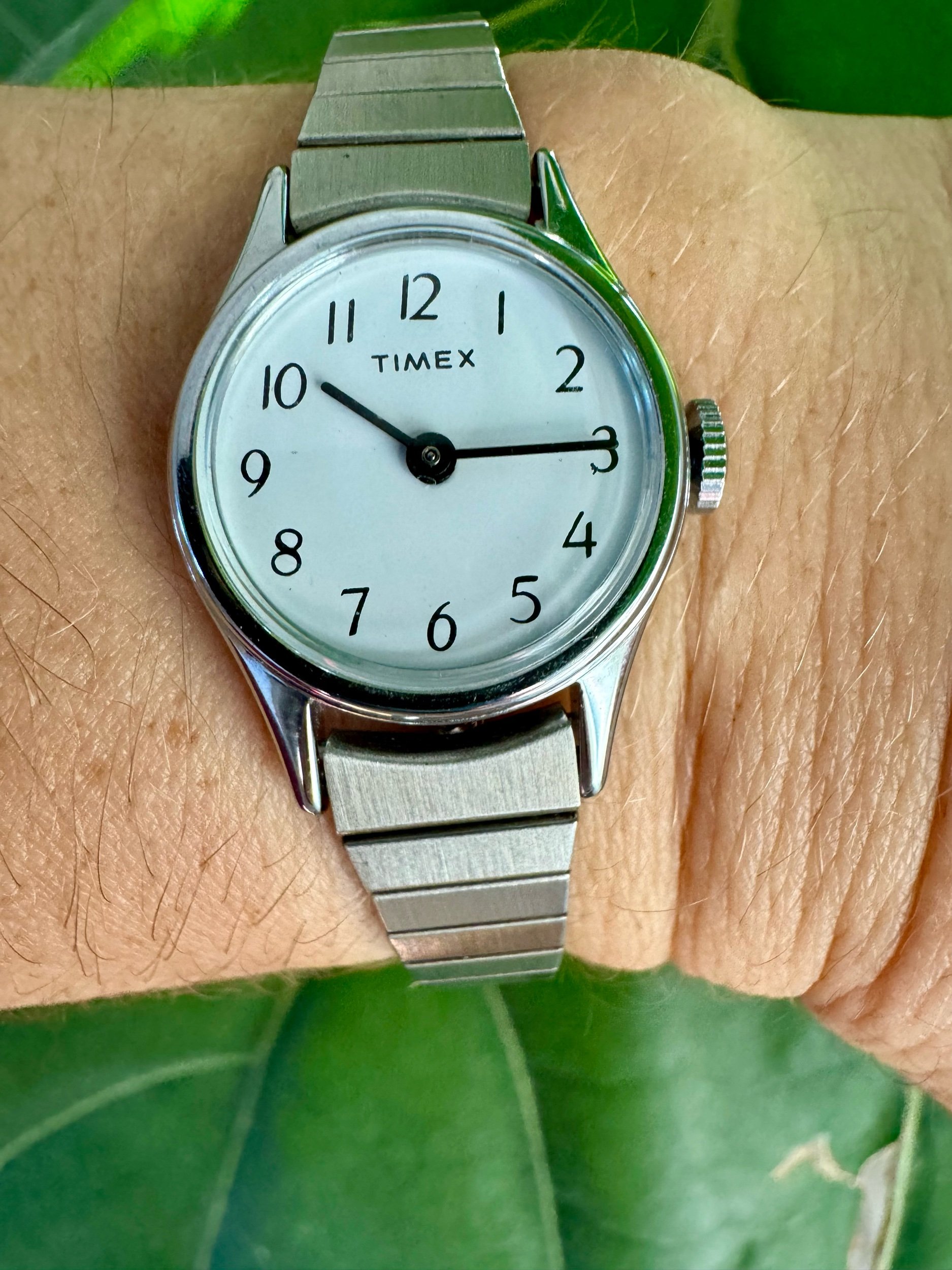 Close-up of vintage Timex watch face, silver-tone design, 1990s mechanical model, showcasing retro elegance