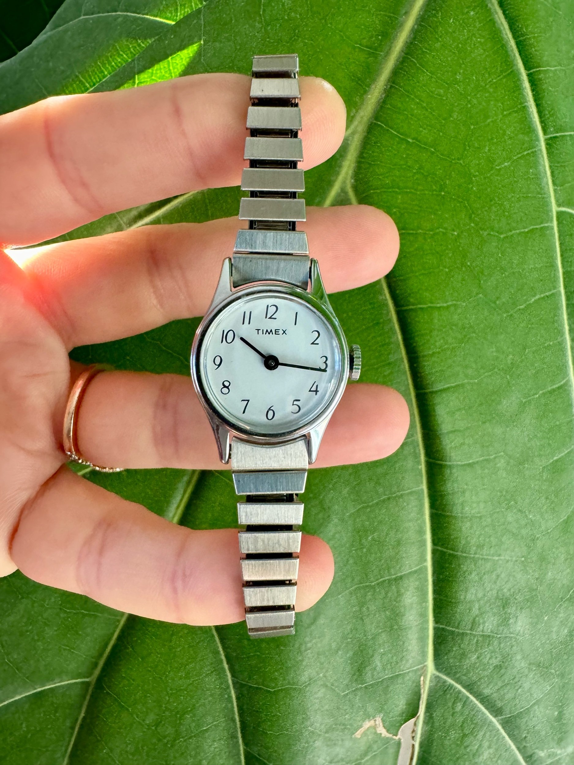 Detailed view of stretch band on vintage Timex watch, silver-tone, fits wrist sizes 5 to 7 inches
