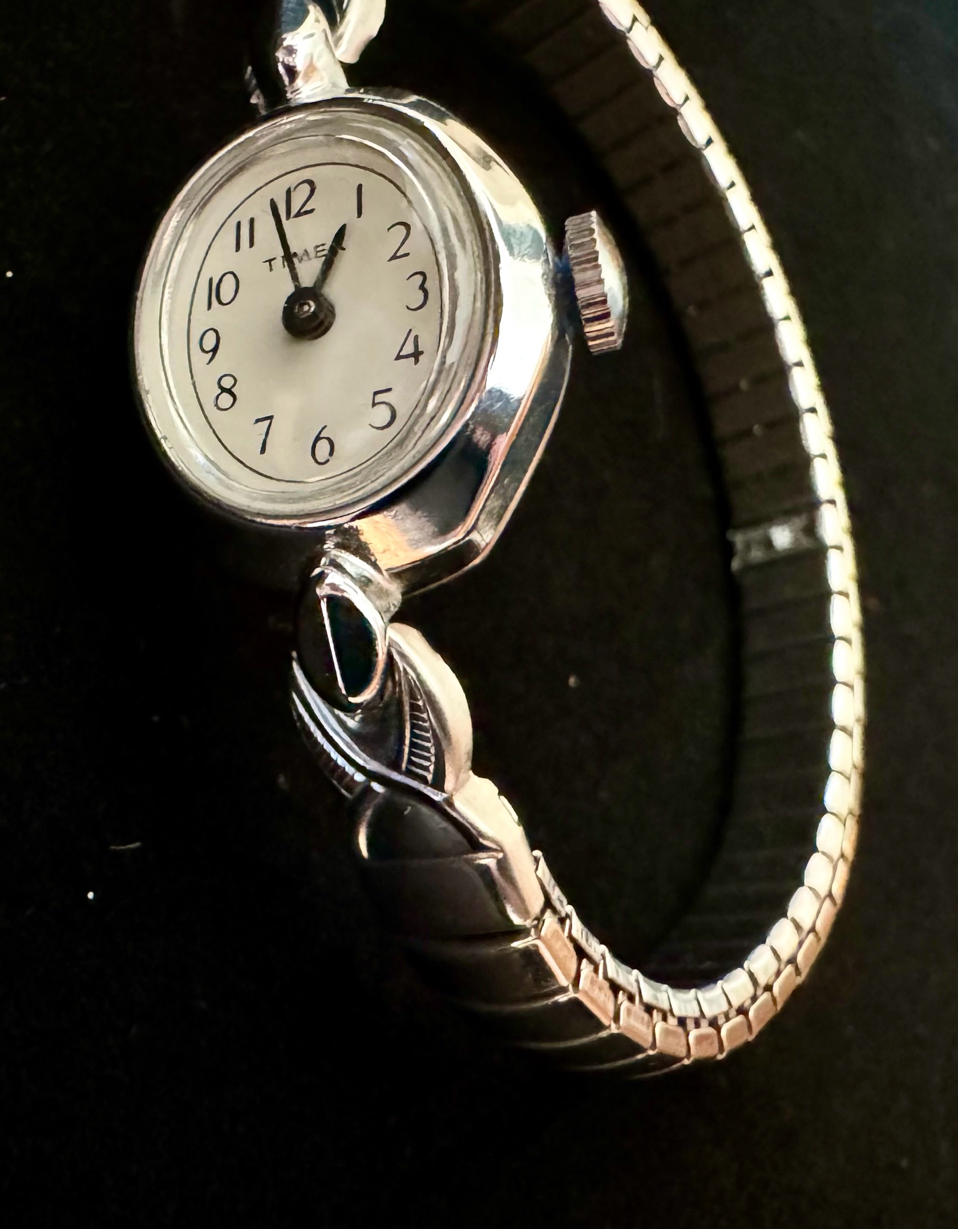 Close-up of vintage Timex watch face with silver finish, showcasing timeless design and mechanical reliability