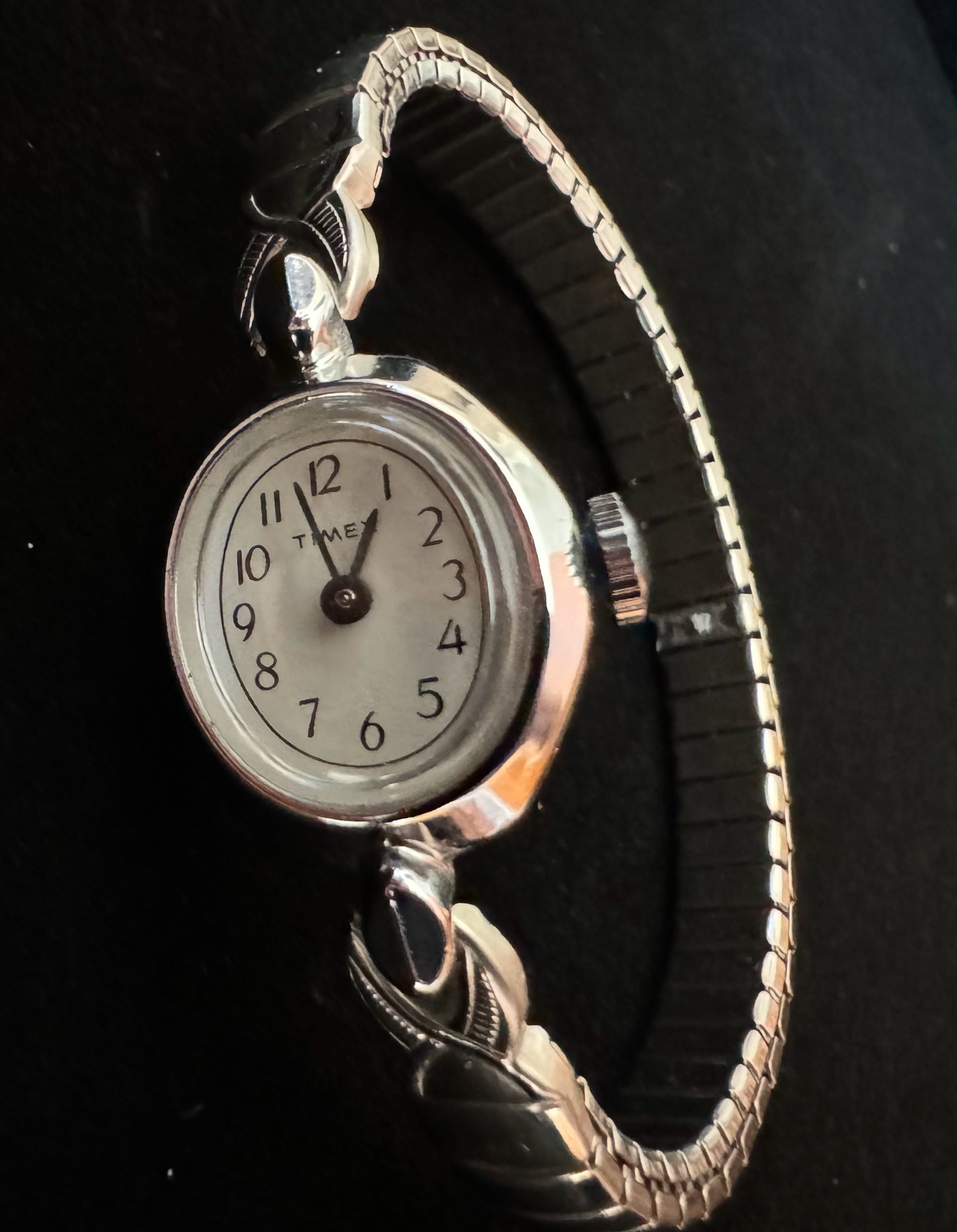 Close-up of vintage Timex watch face with silver finish, showcasing timeless design and mechanical reliability