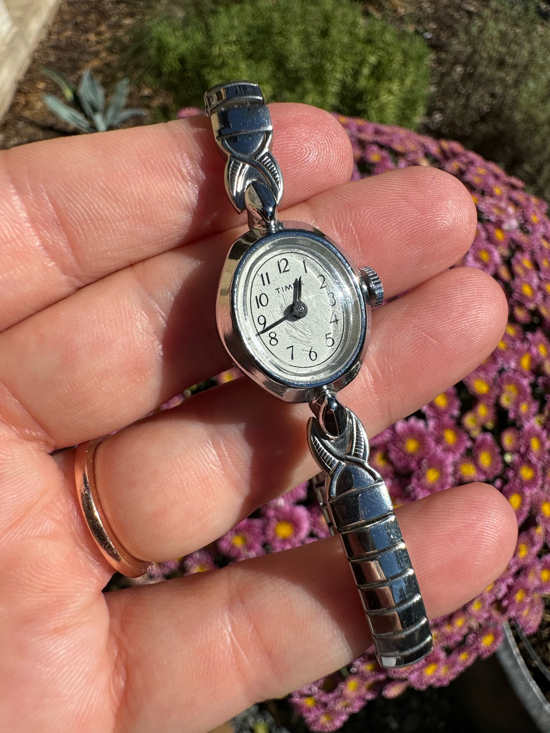 Close-up of vintage Timex watch face with silver finish, showcasing timeless design and mechanical reliability
