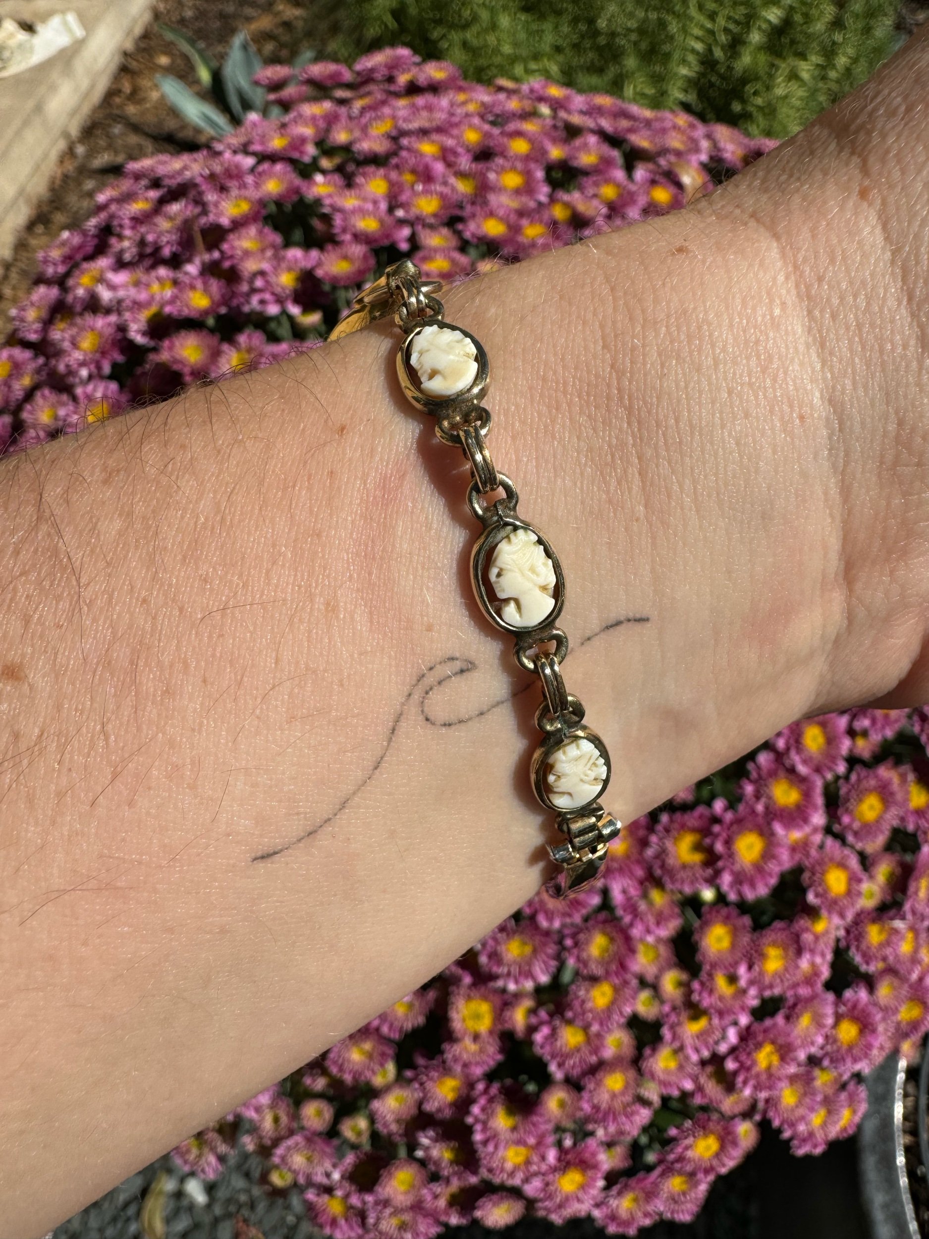 Side view of Waltman gold watch and cameo band, highlighting classic mechanical design and artistic band details.