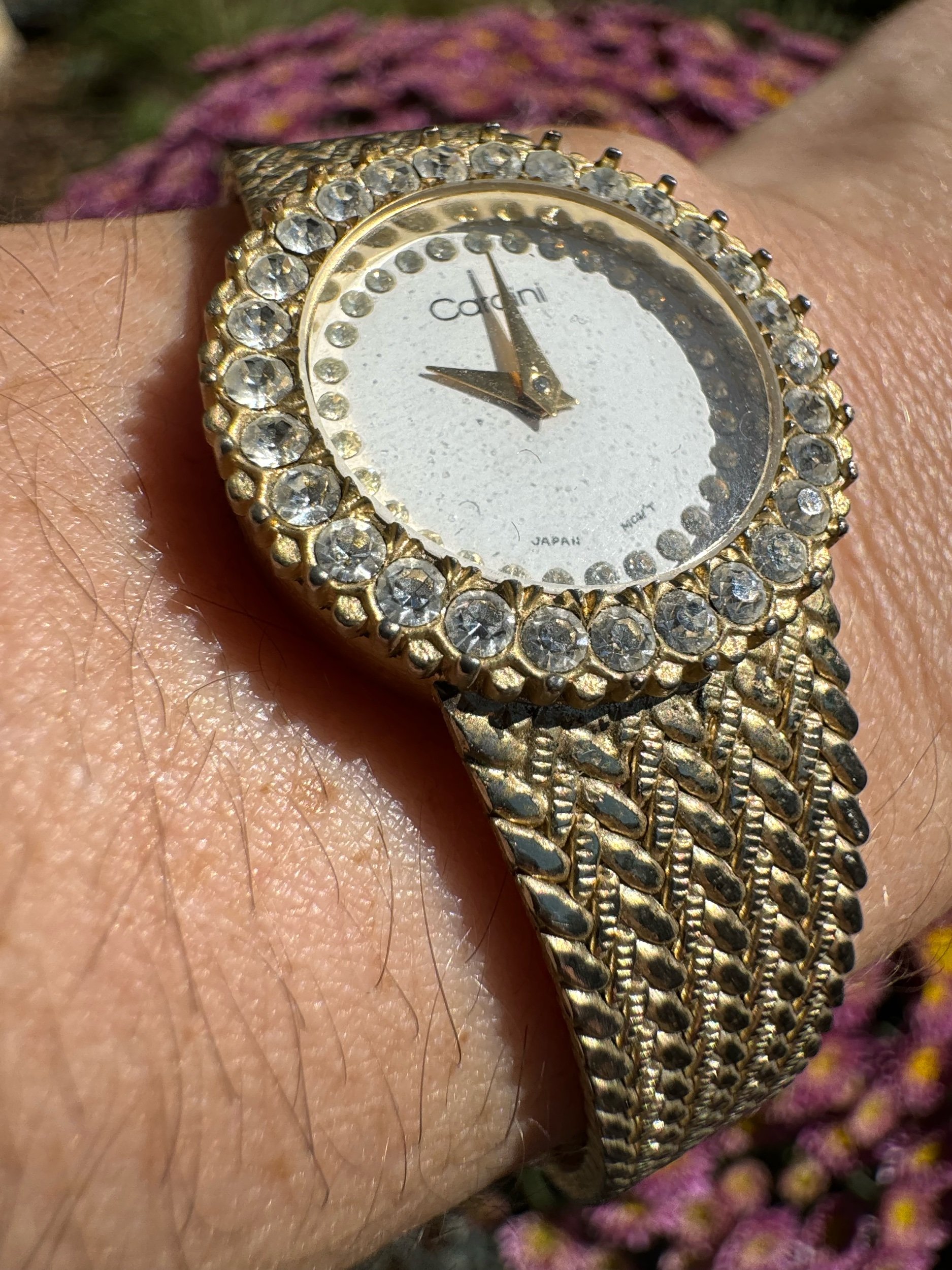 Close-up of vintage Cardini watch face, showcasing intricate details and classic gold finish.