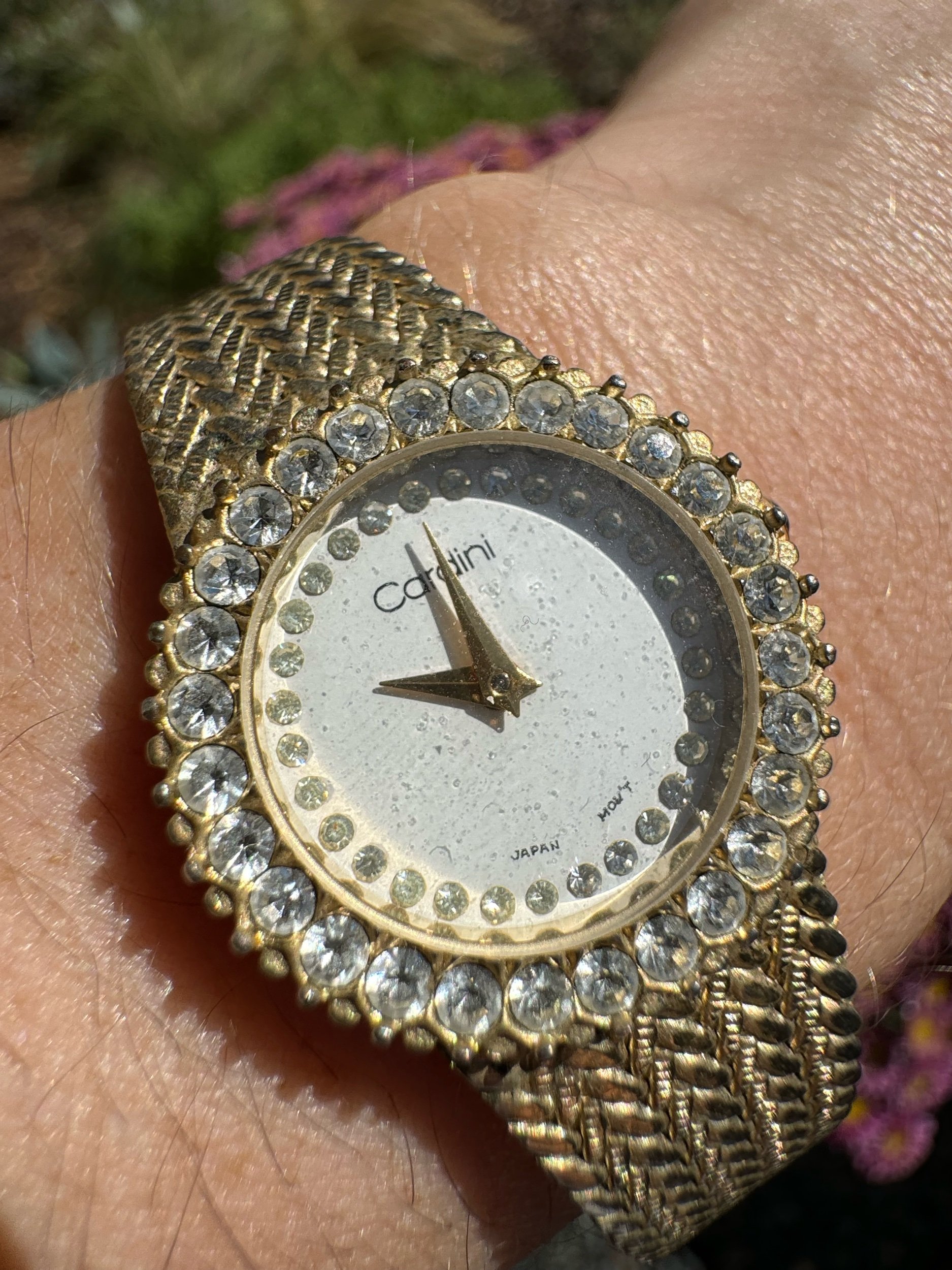 Close-up of vintage Cardini watch face, showcasing intricate details and classic gold finish.